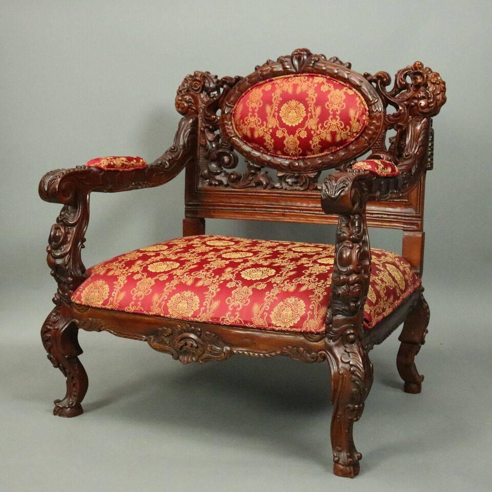 Pair vintage Karpen School Baroque style armchairs feature heavily carved mahogany frame, pierced back including foliate, volute, and acanthus leaves with central upholstered medallion, covered scrolled arms, upholstered seat supported by cabriole
