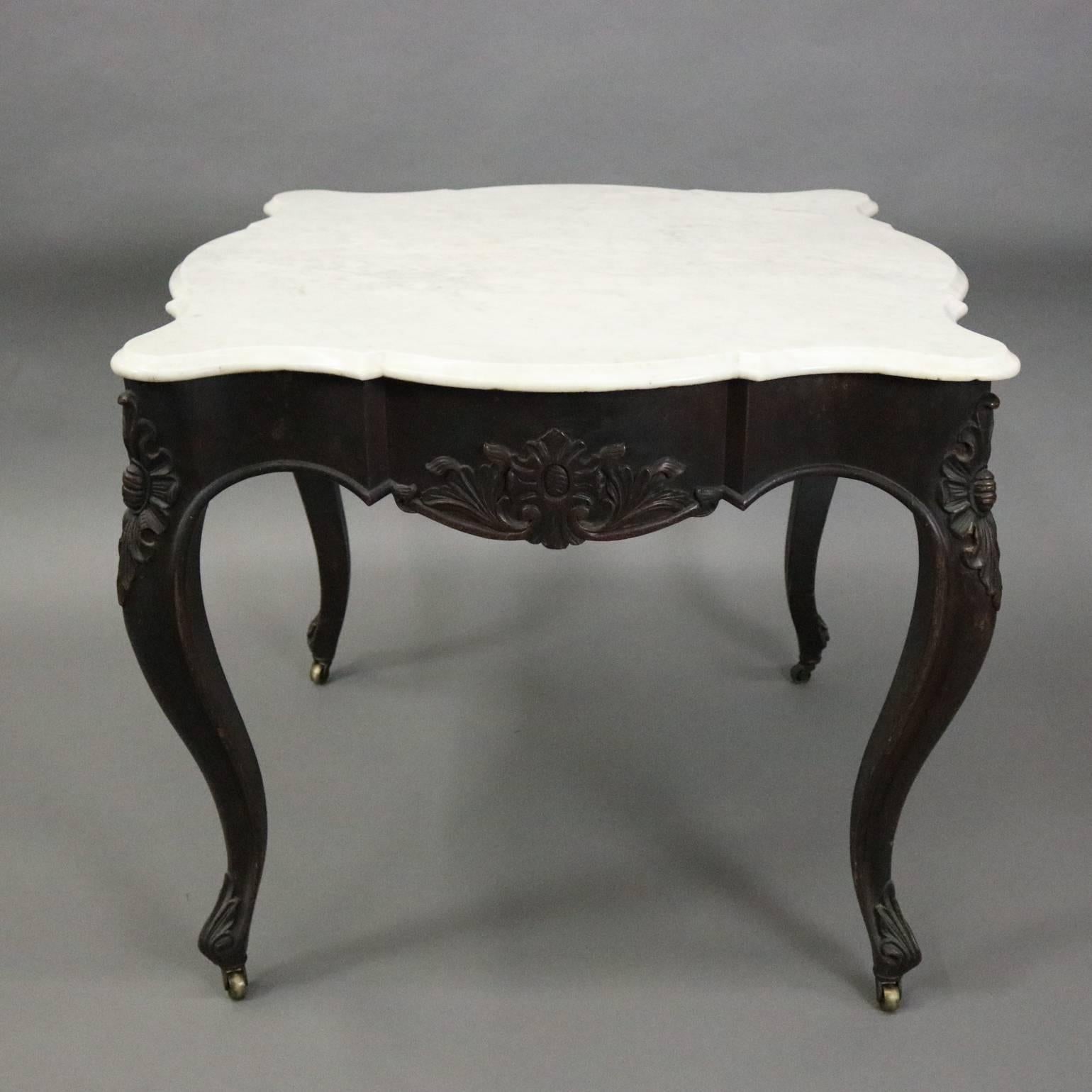 Antique French turtle top game table features walnut construction with carved foliate decoration, cabriole legs, and a scallop form marble top, circa 1880

Measures: 30