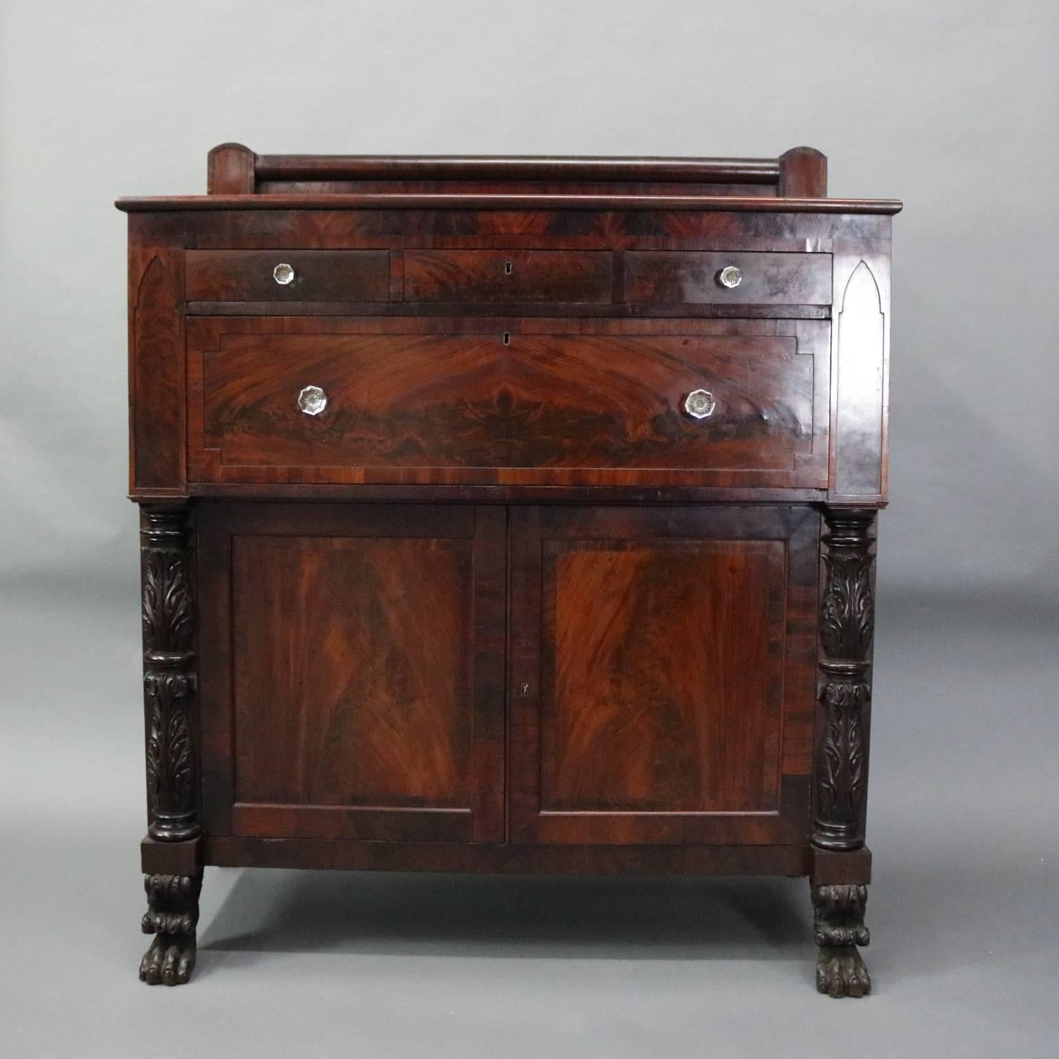 Antique Jackson press features bookmatched flame mahogany doors and drawers with flanking carved acanthus columns supported on paw feet, glass knobs, circa 1850

Measures: 60