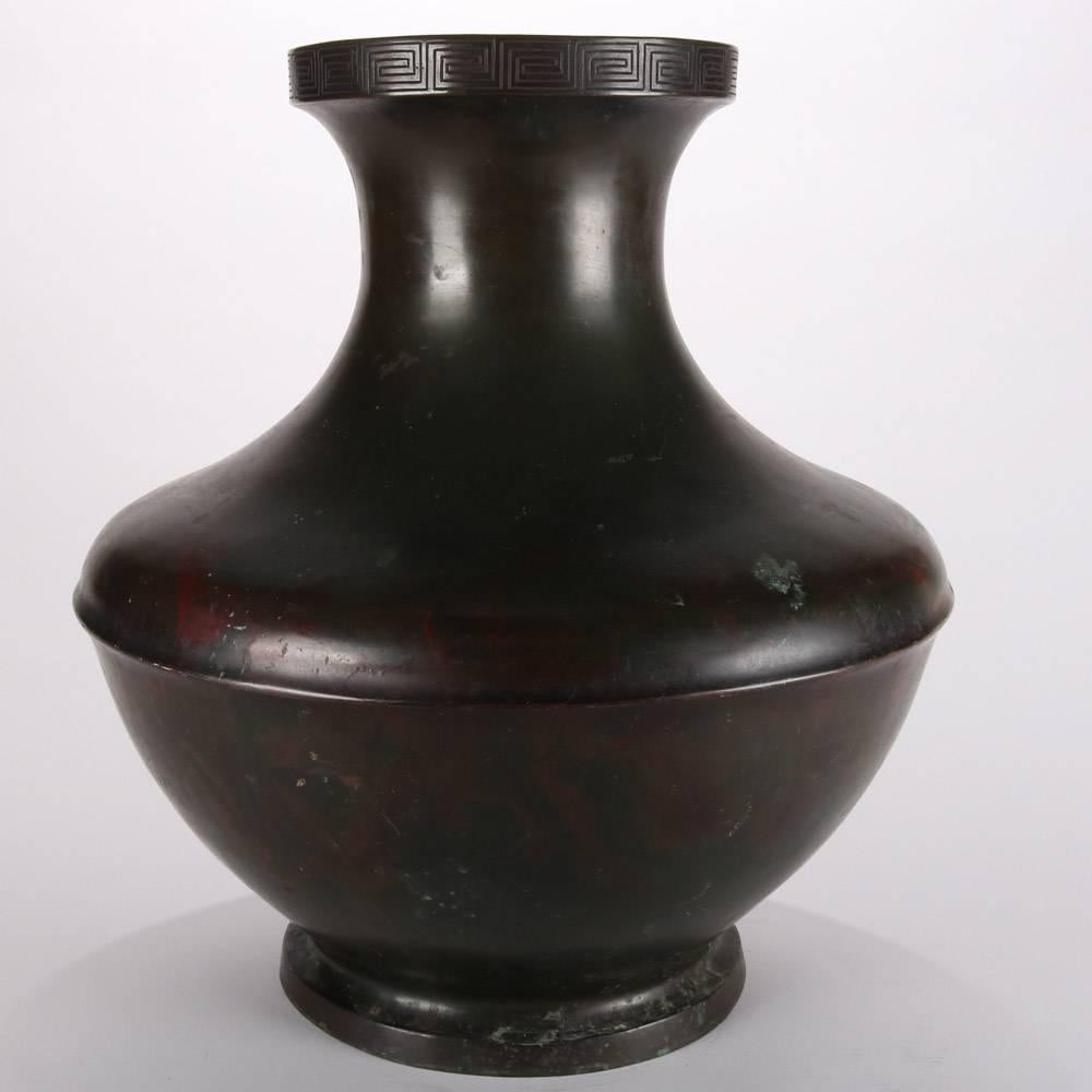 Oversize antique Japanese Meiji bronze floor vase features incised Greek Key pattern on collar, 19th century

Measures: 18" height x 16" diameter, 8" diameter at mouth.