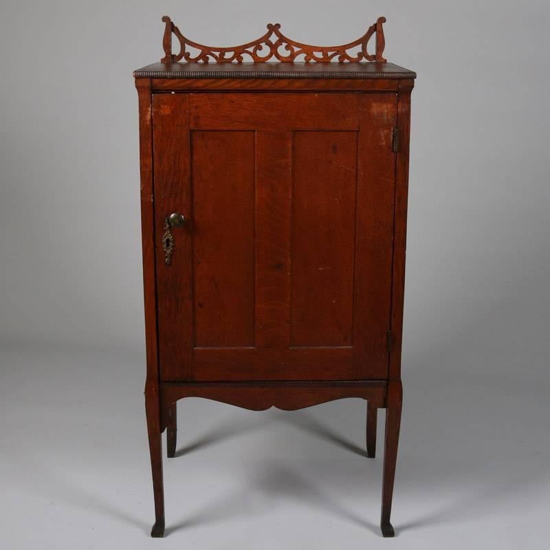 Antique oak Edison cylinder record storage cabinet features scrolled cutout backsplash and pull-out interior record trays, circa 1880

Measures: 39" H x 19.5" W x 15" D.