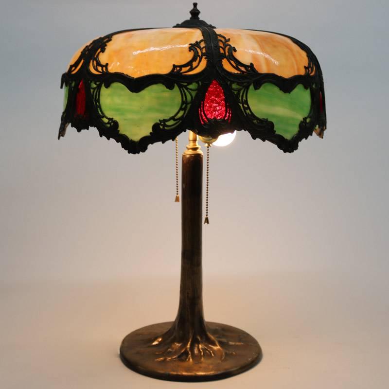 Antique Art Nouveau two-light table lamp by Charles Parker features filigree slag glass shade with foliate decoration on gilt bronze tree form base, School of Tiffany, 20th century

Measures 24" H x 16" diameter.