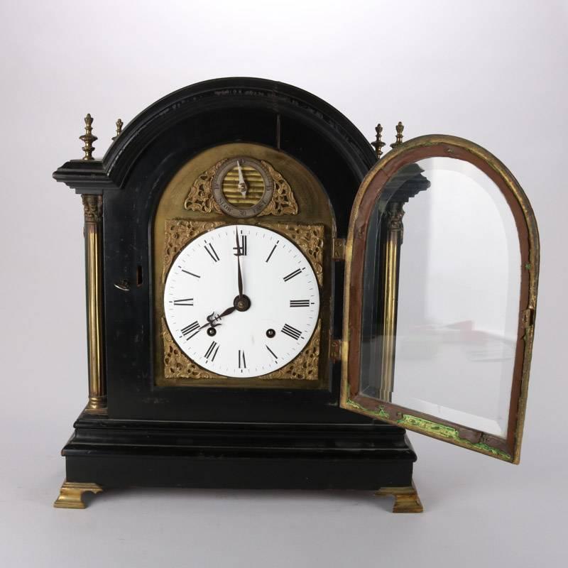 Antique English Tiffany & Co. bracket clock features ebonized case with bronze accoutrements including flanking columns, working condition with pendulum and key, 19th century.

Measures: 19