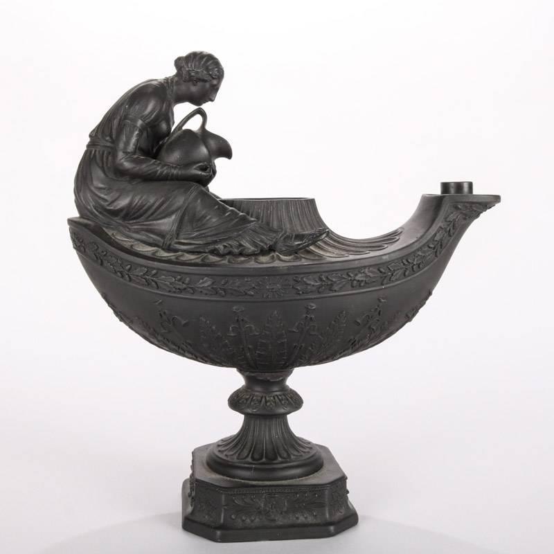 Antique English Wedgwood black basalt figural oil lamp features woman reading book atop vestal urn oil lamp, 19th century

Measures: 8.5" H x 8" W x 4" W.