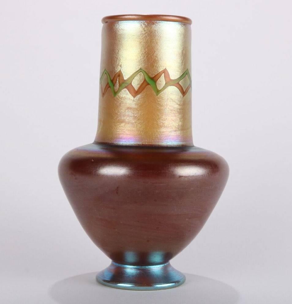Antique and rare Tiffany Favrile "Tel El Amarna" vase with Egyptian Collar features iridescent art glass with pulled zig zag decoration on neck, inscribed "9016G L.C. Tiffany Favrile" on base, polished pontil, early 20th