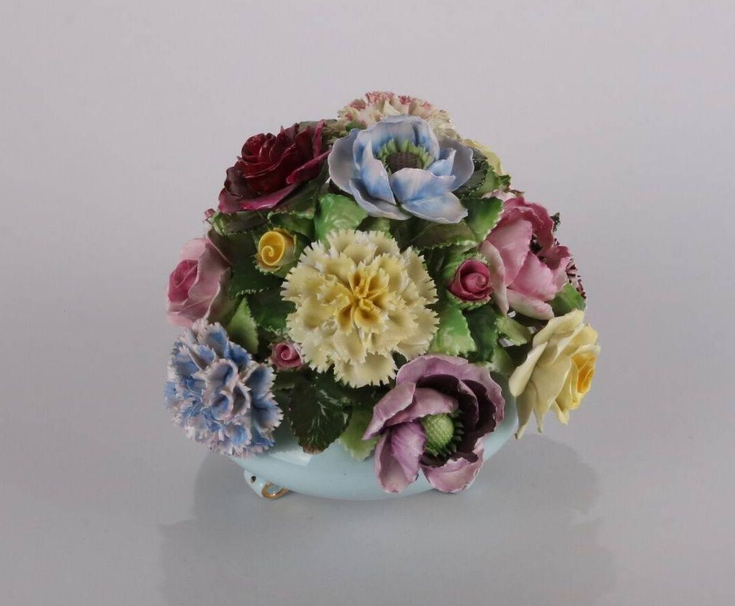 Bouquet anglais en porcelaine Royal Adderley avec des fleurs en porcelaine peintes à la main dans un vase décoré de dorures et de pieds:: timbre au verso

Mesures : 7" ; hauteur x 7" ; diamètre.