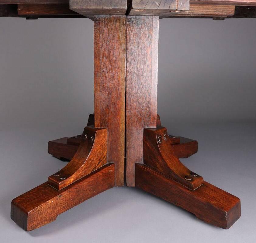 Antique Arts & Crafts Stickley Brothers Mission oak dining table features quarter sawn oak construction with stylized straps on apron, includes two leaves, table can be located in the Stickley Brothers Company catalog "Quaint Furniture,