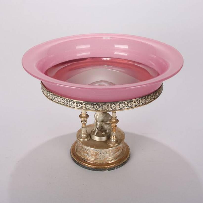 Antique Steuben Rosaline glass centre bowl on Reed & Barton silver plate figural stand with whippet (dog) seated within Corinthian columns, 19th century

Measures: 8.5" h x 11.75" diam