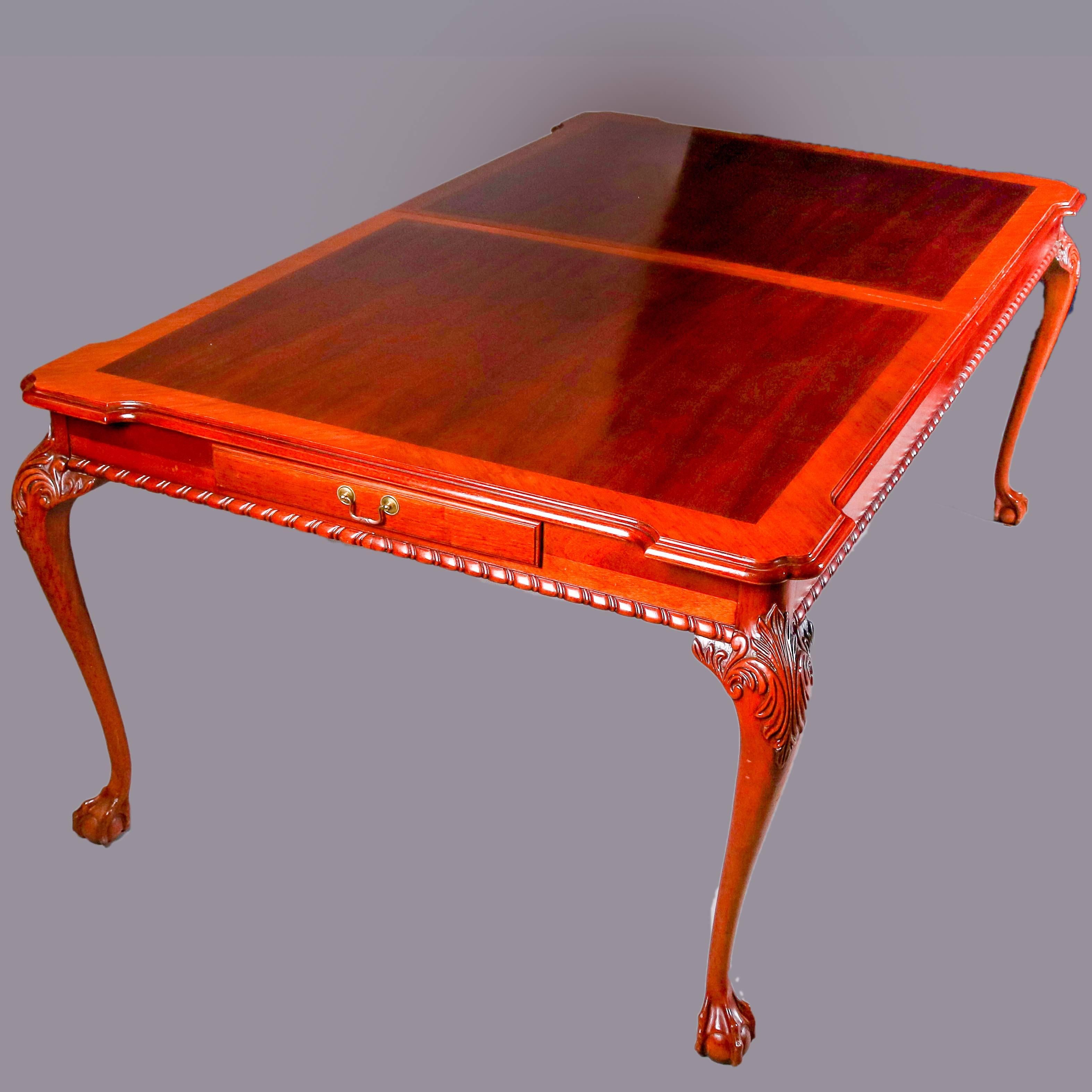 Chippendale style mahogany dining table features shaped two toned dining surface above twisted rope apron and including silverware drawers, seated on cabriole legs with carved acanthus knees and terminating in claw and ball feet, two matching two