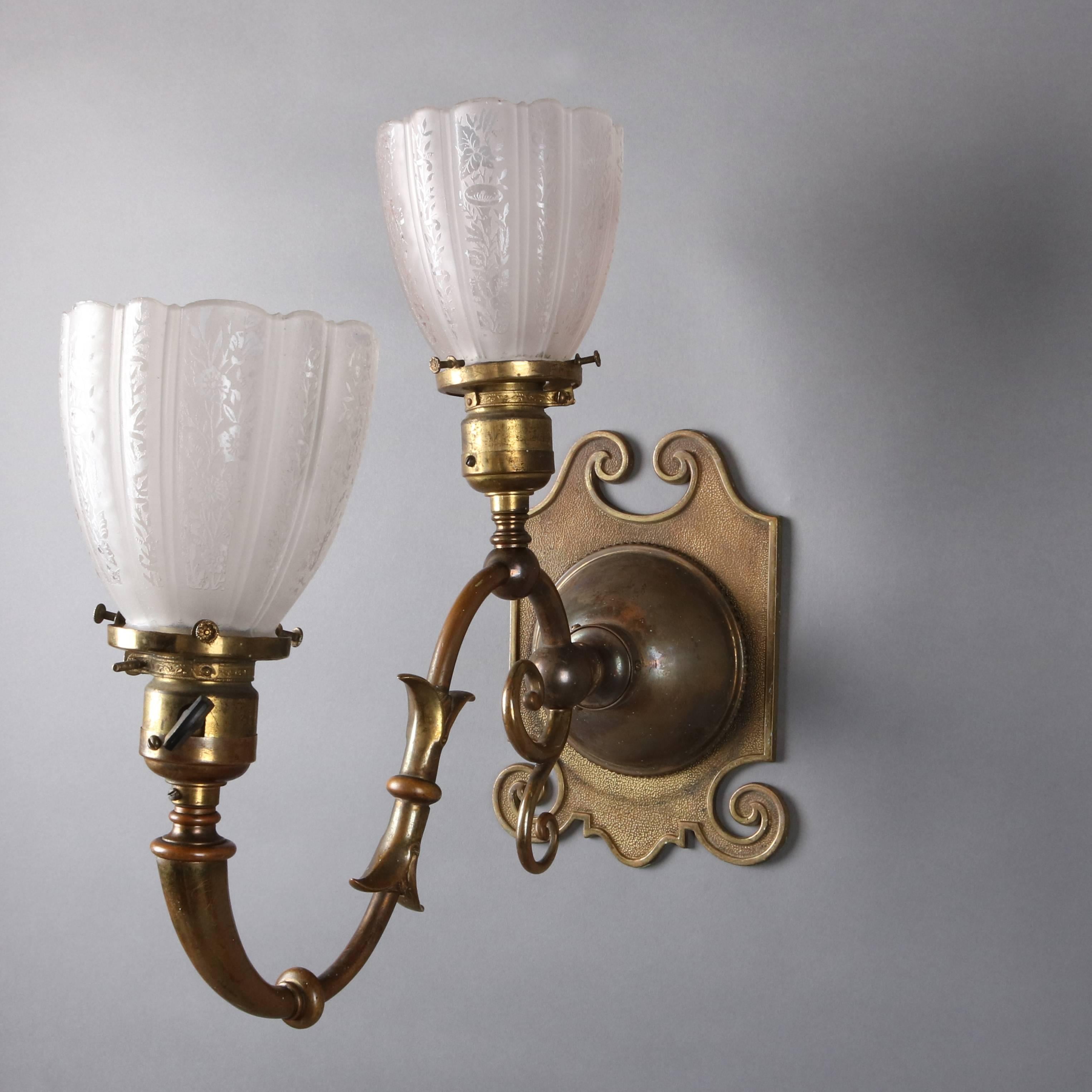 Set of four antique Arts & Crafts early electric wall sconces feature scroll and foliate form arms terminating in two lights each with floral and foliate etched shades, converted from gas to electric, newly re-wired.

Measures: 13" H @ h