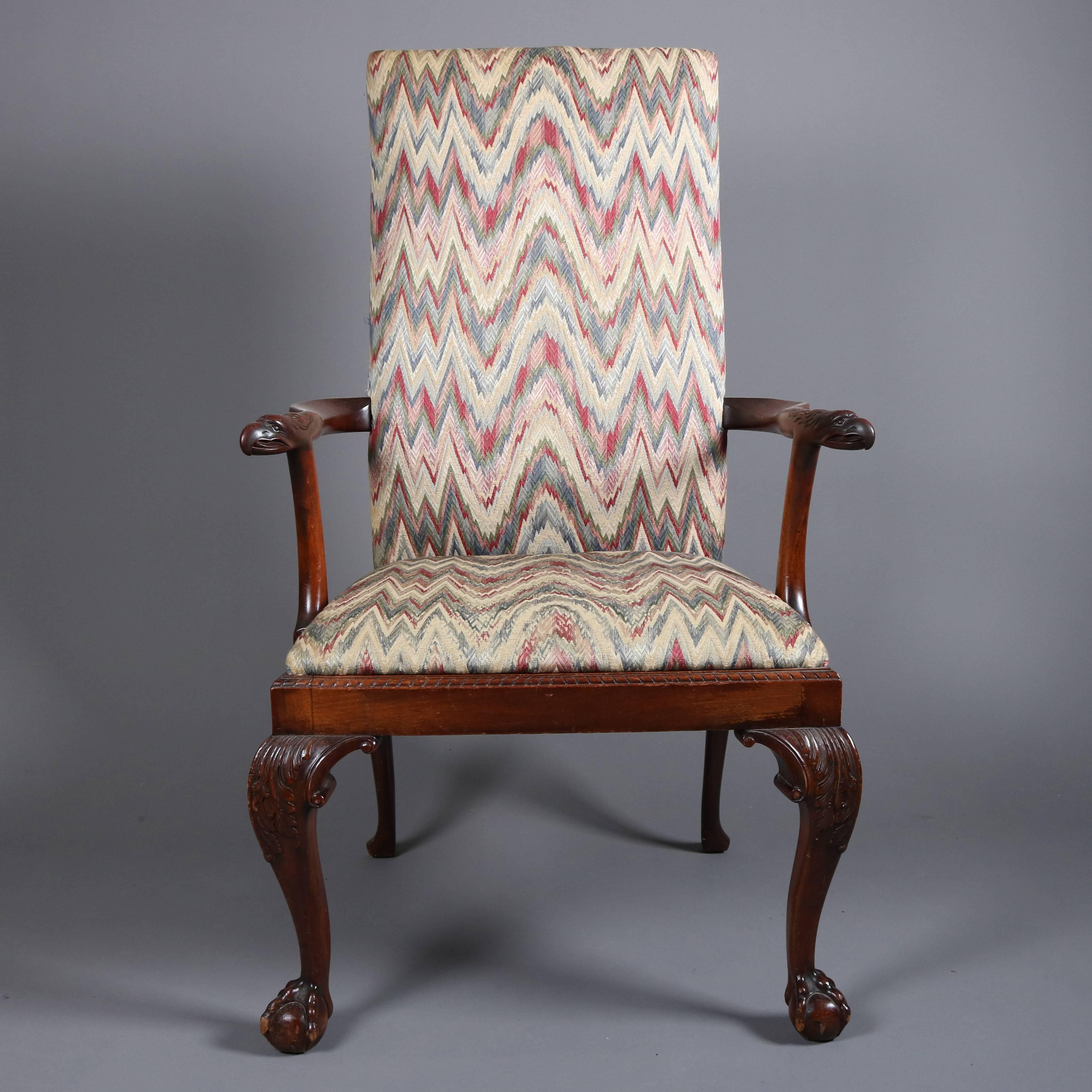 Antique mahogany figural Chippendale lolling armchair features carved falcon arms and claw and ball feet, flame stitch upholstered seat and back, 19th century

Measures: 48" H x 27.5" W x 22" D, 18" seat H.