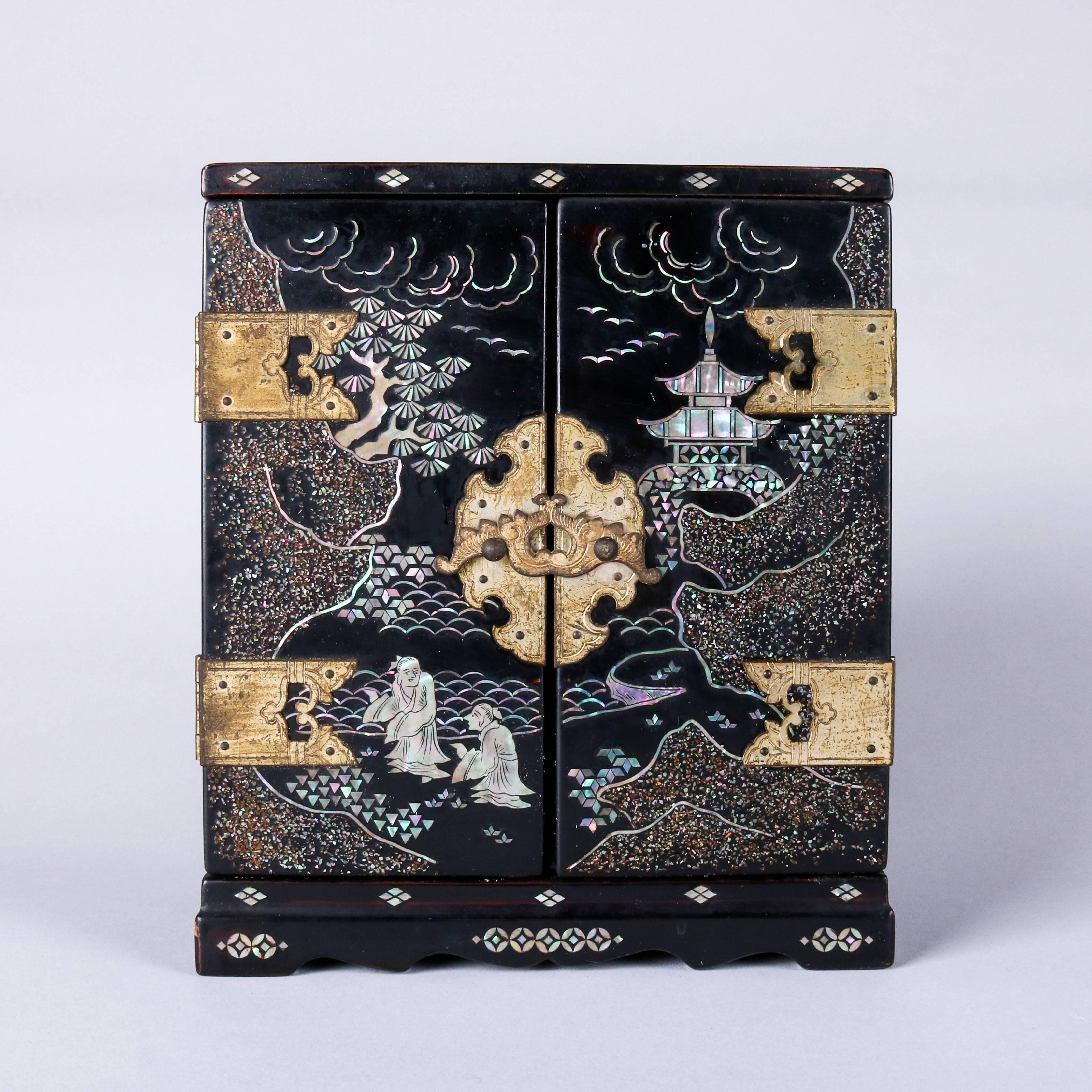 Vintage Japanese ebonized musical jewelry box features mother-of-pearl inlaid village and landscape scenes, velvet lined interior compartments, plays music when doors are opened, 20th century

Measures - 7.75" H x 6.5" W x 4.25" D.