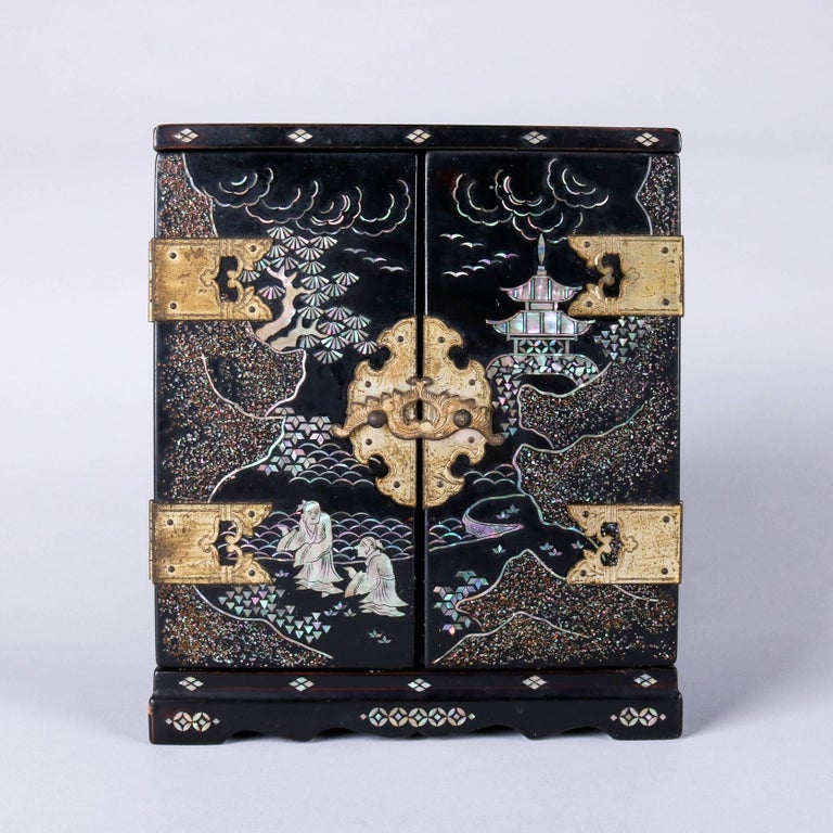 Vintage Japanese ebonized musical jewelry box features mother-of-pearl inlaid village and landscape scenes, velvet lined interior compartments, plays music when doors are opened, 20th century

Measures - 7.75" H x 6.5" W x 4.25" D.