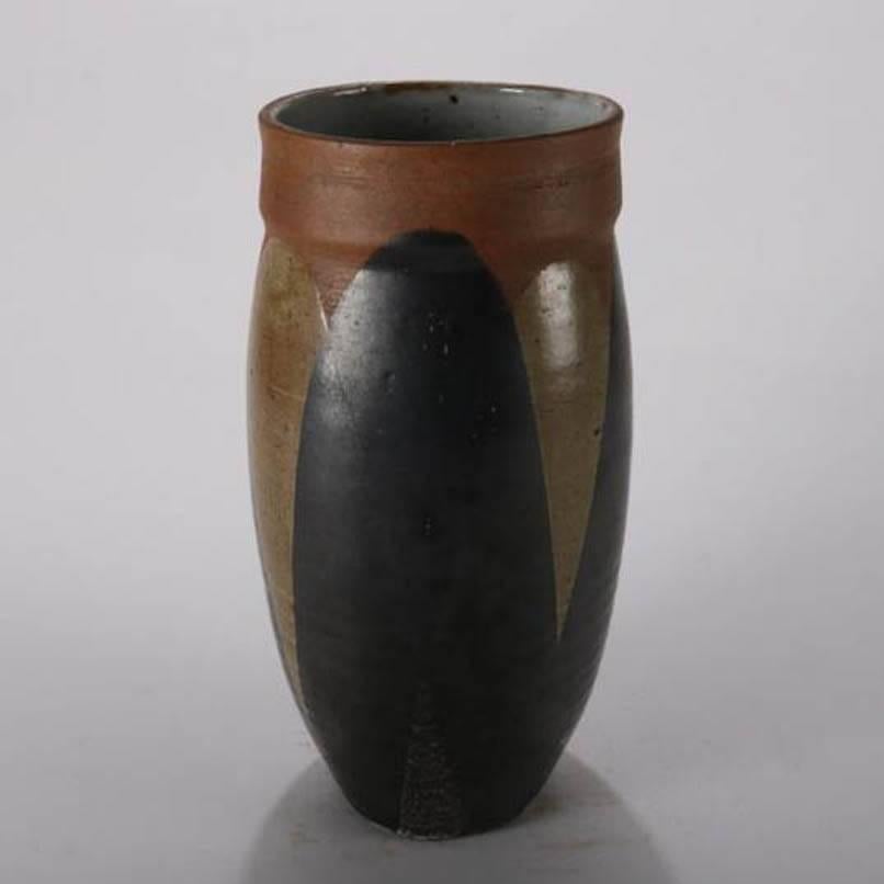 Mid-Century Modern hand-thrown and glazed studio pottery tall vase with repeating stylized overlapping foliate leaf design, mid-20th century
Provenance: Deaccessioned from the Randy Webb Collection of the Call Museum, Hartsville, New York

Measures