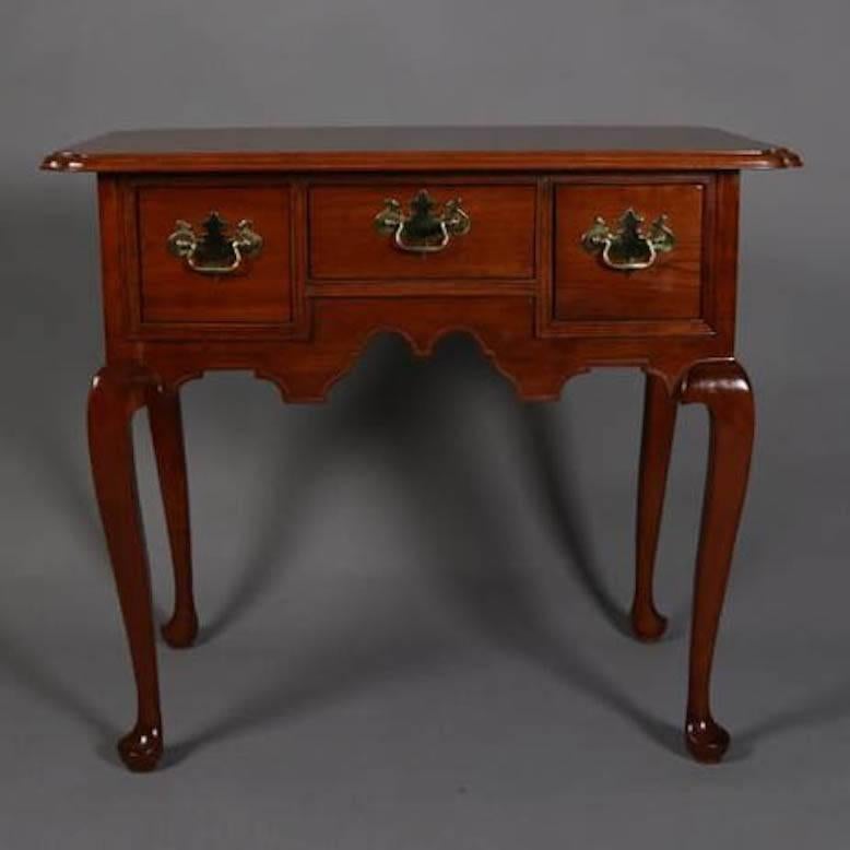 Vintage L. & J. G. Stickley Cherry Valley Collection lowboy server features shaped top above three drawer cabinet with scalloped apron, seated on cabriiole legs, bronze pulls, Leopold Stickley  and L&JG Stickley labels inside drawer, 20th