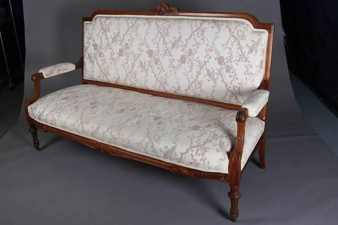 Antique French Louis XVI parlor set features walnut settee and armchair with carved foliate, scroll and shell decoration, floral upholstered seat, back and arms, 19th century

Measures - sf: 44.5" H x 70" L x 26" D, 18" seat, ch: