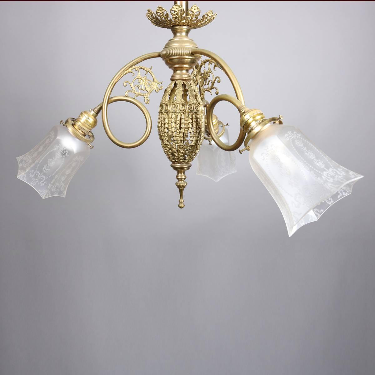 Three-arm brass chandelier features pierced egg form body with scroll and foliate form arms terminating in lights with faceted floral etched frosted shades, newly re-wired, 20th century

Measures - 60" drop, 24".