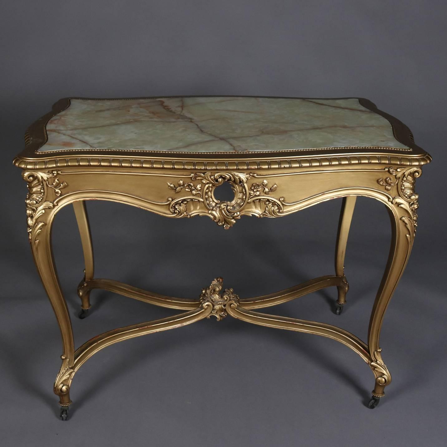 Antique French Louis XIV centre table features gold giltwood floral and foliate frame with pierced apron seated on cabriole legs and having inset onyx top, 19th century

Measures - 32