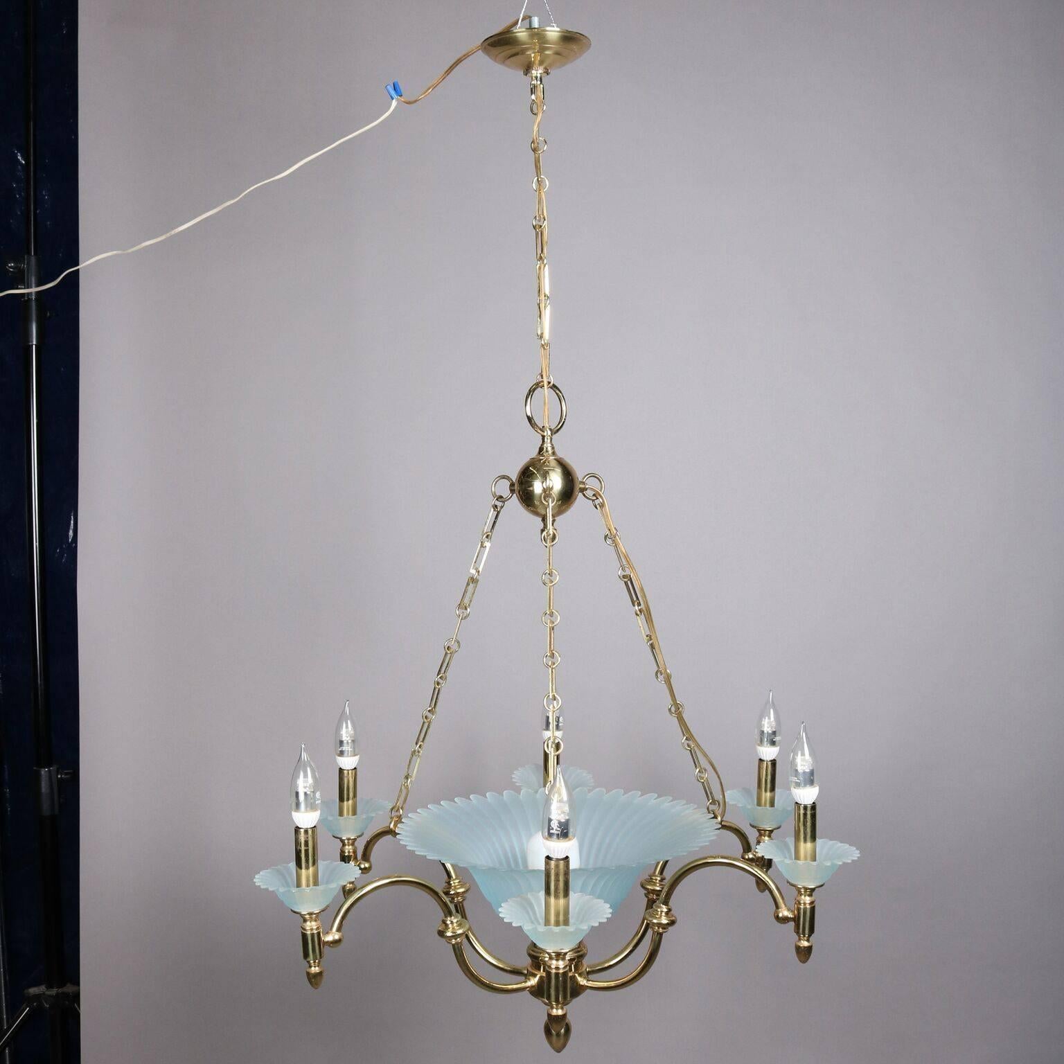 Hollywood Regency chandelier features brass frame with central fluted aqua opalescent glass ribbed bowl with six scroll form arms terminating in candle lights with matching glass bobeches, 20th century

Measures - 46" drop, 28".