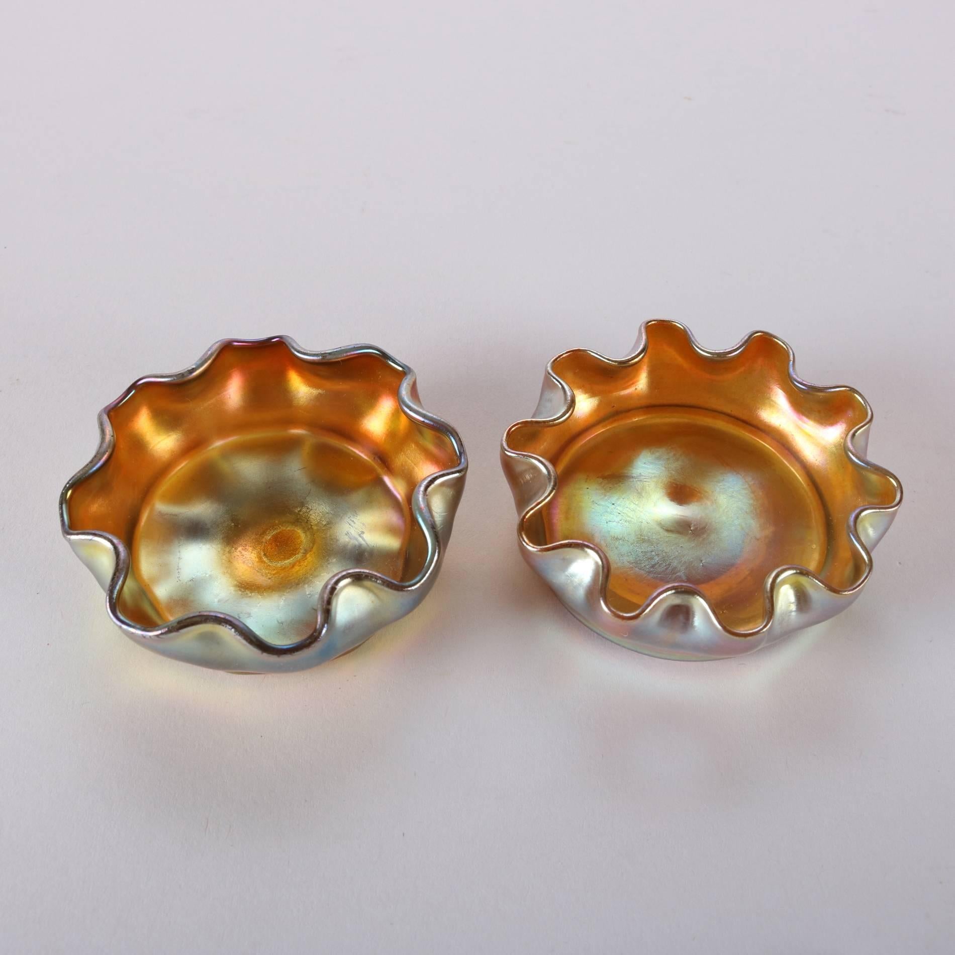 Pair of antique gold Favrile art glass salt cellars by Louis Comfort Tiffany feature with iridized exterior finish and ruffled rims, signed on bases L.C.T., 19th century

Measure: 1