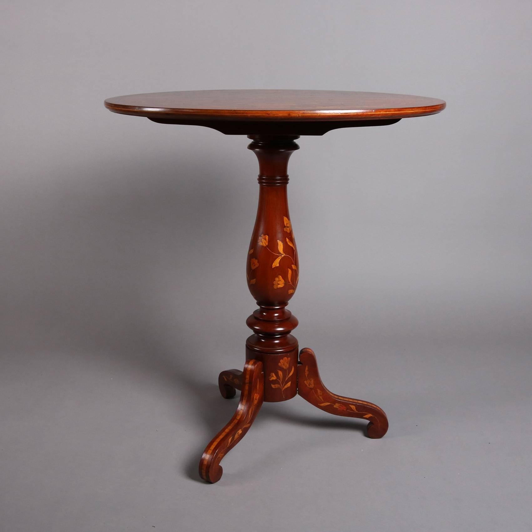 Antique mahogany tilt-top table features satinwood marquetry in floral, foliate and urn design, seated on turned and inlaid pedestal with three legs, 19th century

Measures: 31