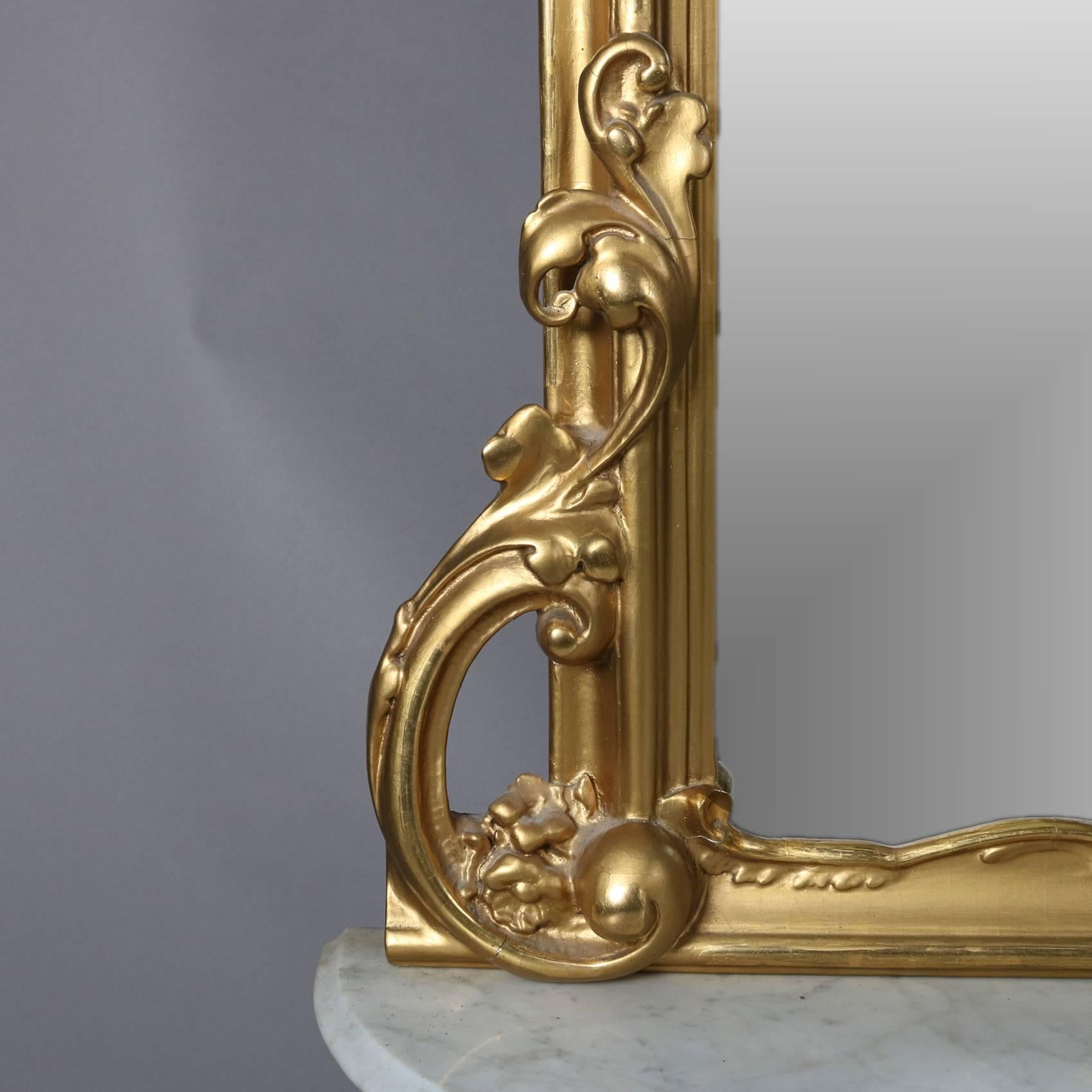 Antique French Louis XIV style pier mirror features scroll and foliate form giltwood frame with pierced crest and apron, marble top base seated on cabriole legs, 20th century

Measures - bs: 16