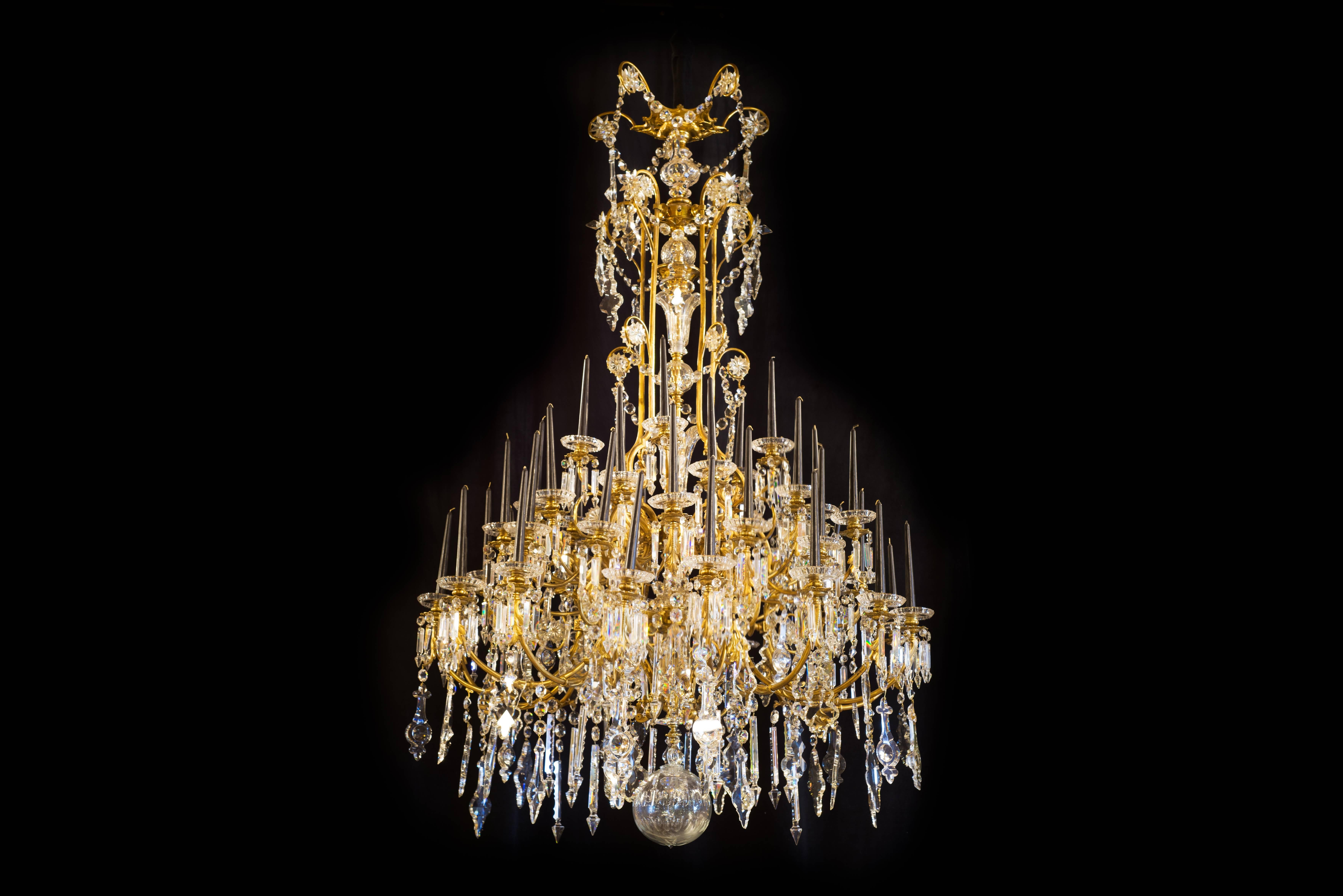 19th century chandelier - column and arms made of bronze. 

Baccarat crystal glass bells and cups. Over 15 different shapes of crystal. 

Forty four points of light - one candle for each point. 

The chandelier was overhauled 6 years ago and
