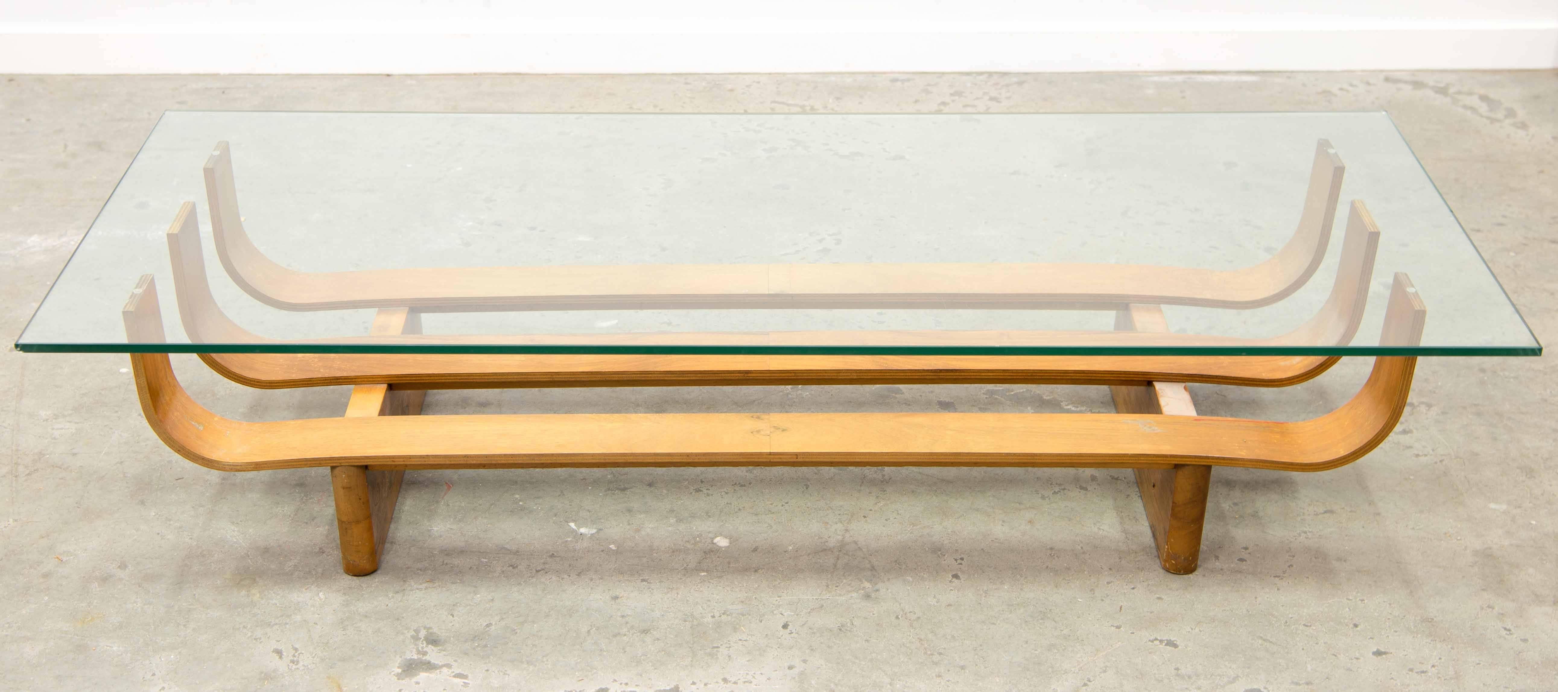 The Coffee Salon Table was made around 1970 in Denmark, Europe. It is made of a plywood base and is curved up so it can support a large plane of glass. The glass is in good condition without any chips on the sides. There is an original 'Ilse Möbel'