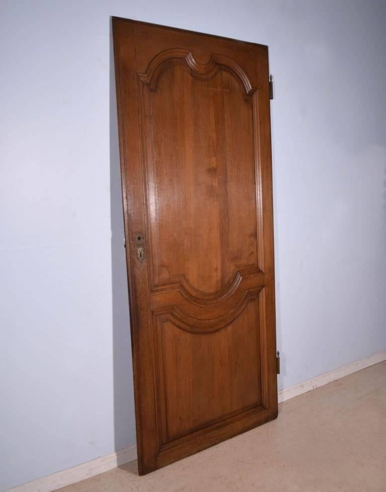 This elegant antique door is from France and it dates to the late 1700s or early 1800s. All of the woodwork is hand carved from solid oak and finished to a warm medium oak color. This was an interior door and therefore shows no weather damage.