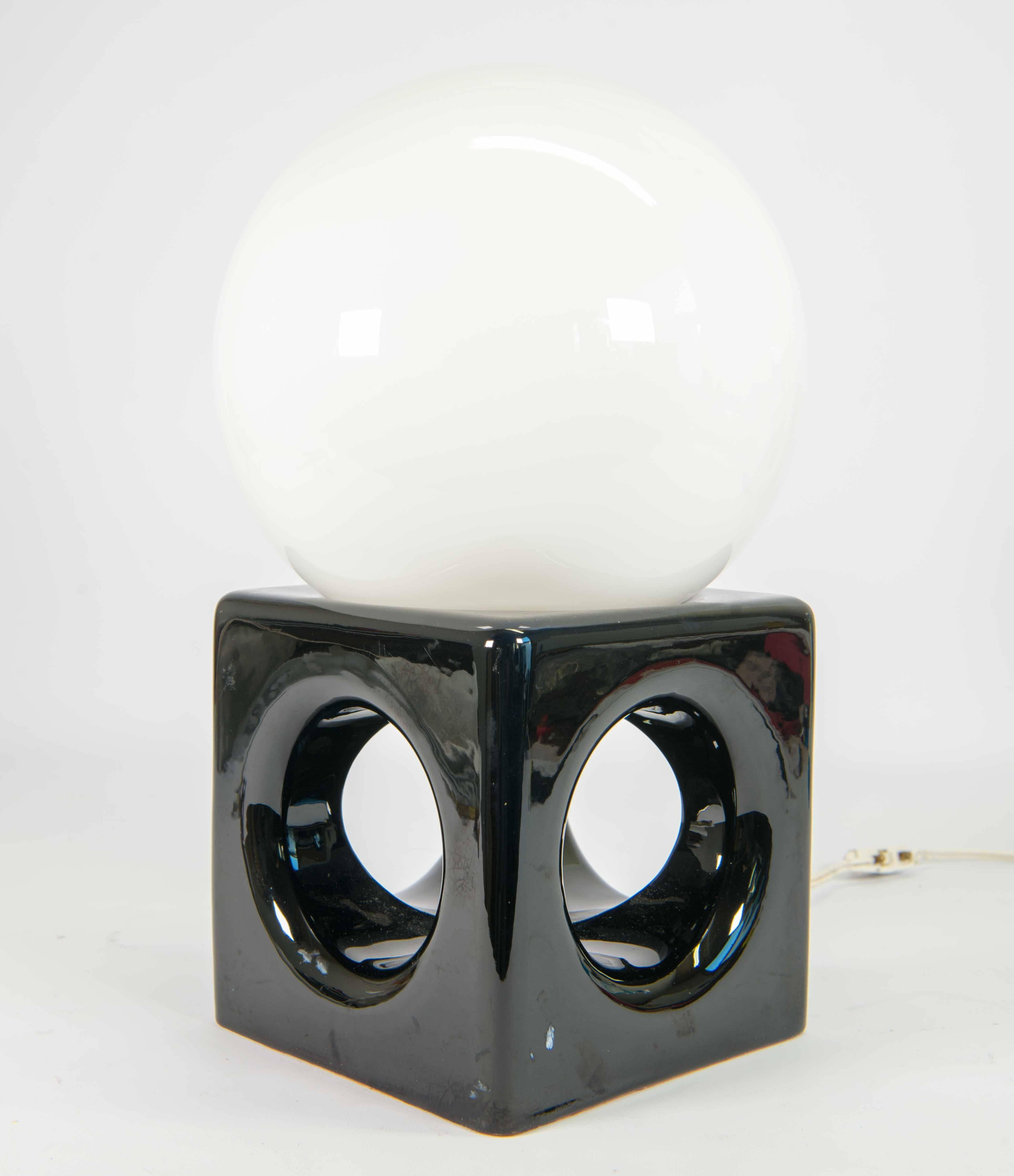 Table lamp with porcelain base in black color holding a white sphere. The sphere is made of frosted glass.
Lamp was most likely made circa 1950 in Belgium.
It is unmarked. European wires are present, yet these can be changed to US wiring on