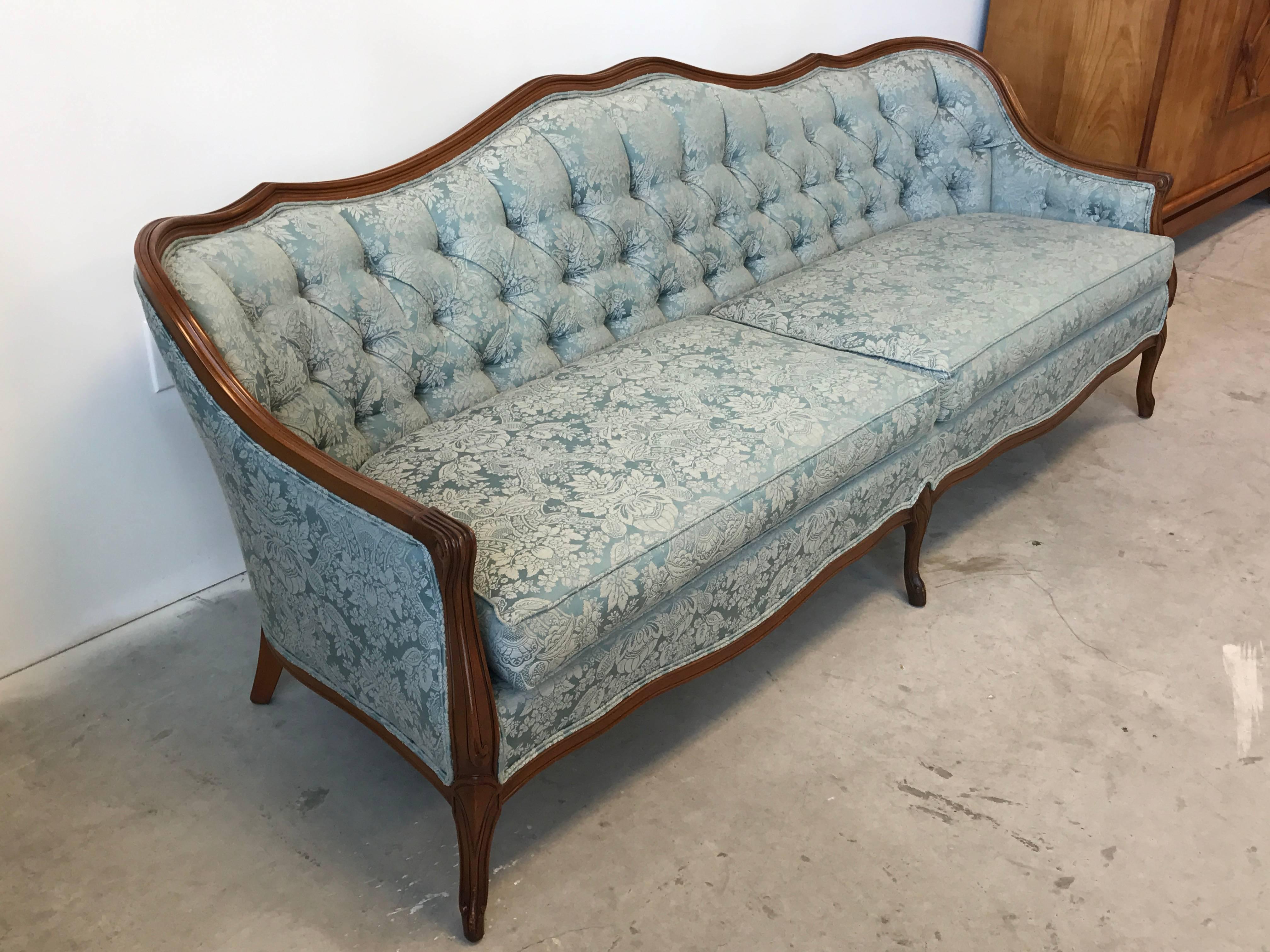 Offered is a beautiful, 1940s French tufted sofa, upholstered in original, blue damask with an oak frame border.