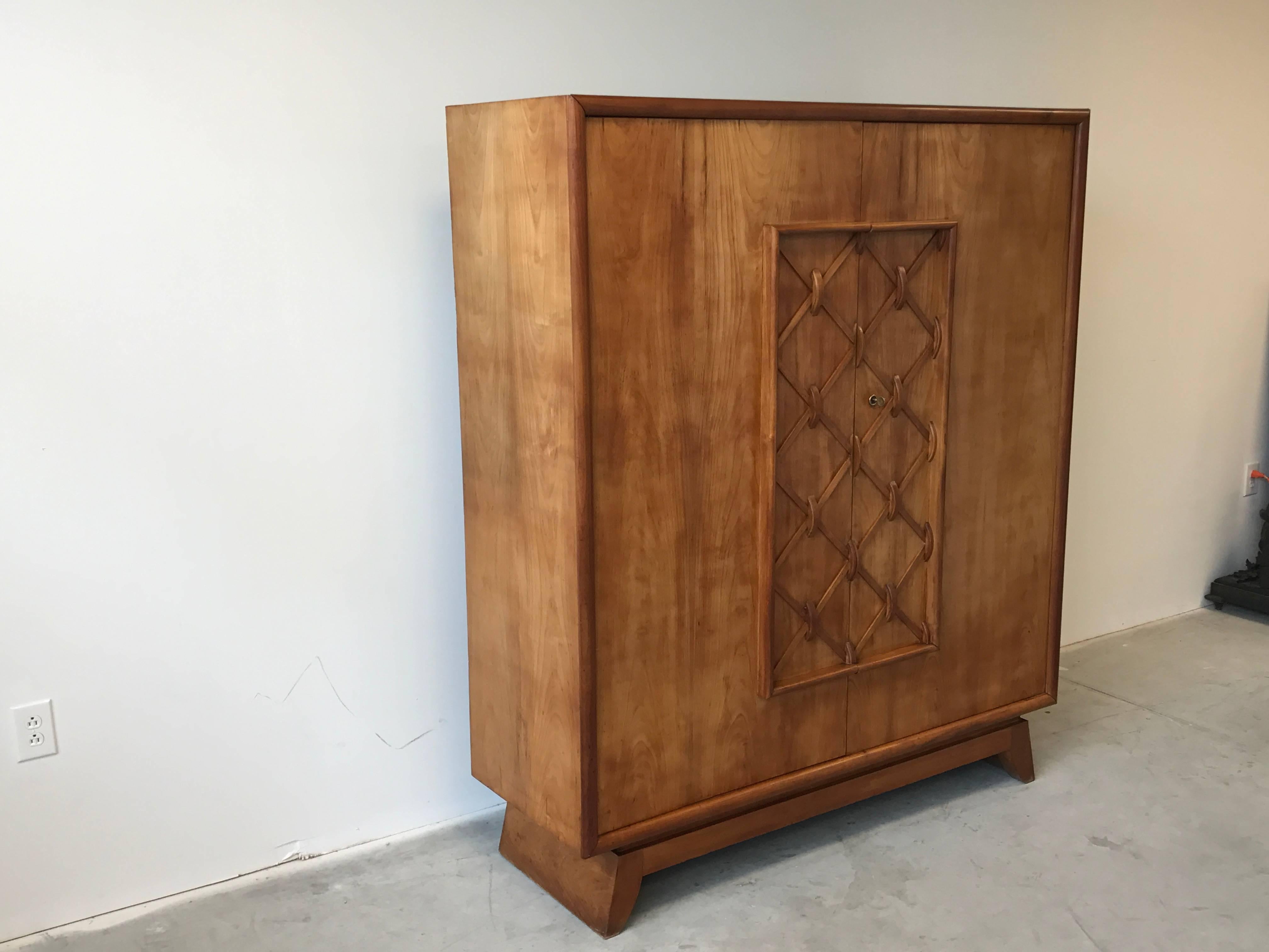 Featured is an exquisite solid maple double door cabinet with six fixed shelves and two pull-out drawers in the manner of French designer Jean Royere, circa 1930s. The chest was likely intended to be used as a gentlemen's sundries cabinet for