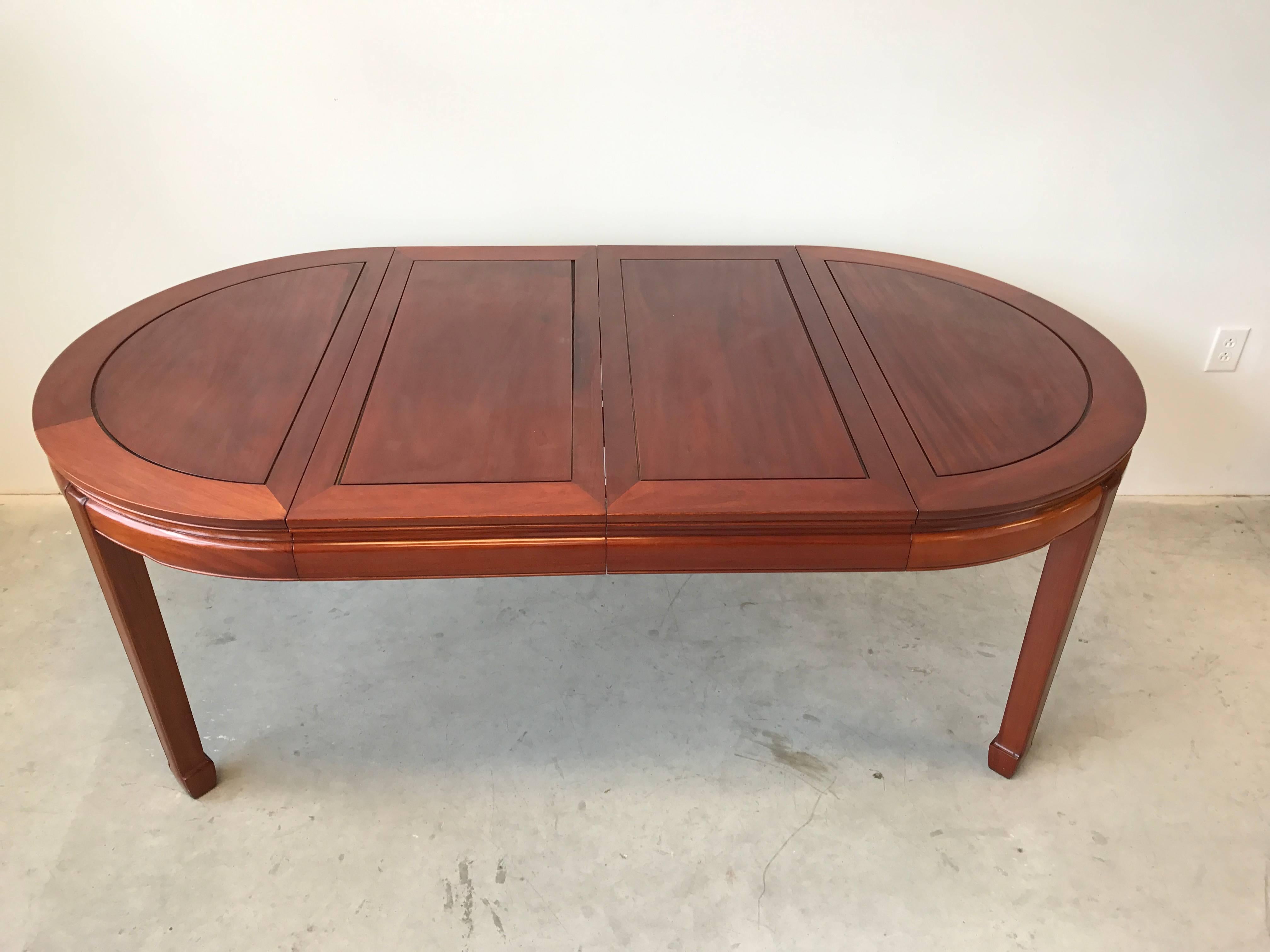 Offered is a stunning, 1960s Ming style rosewood dining table. The piece includes two leaves and table pads. 

Each leaf measures 18