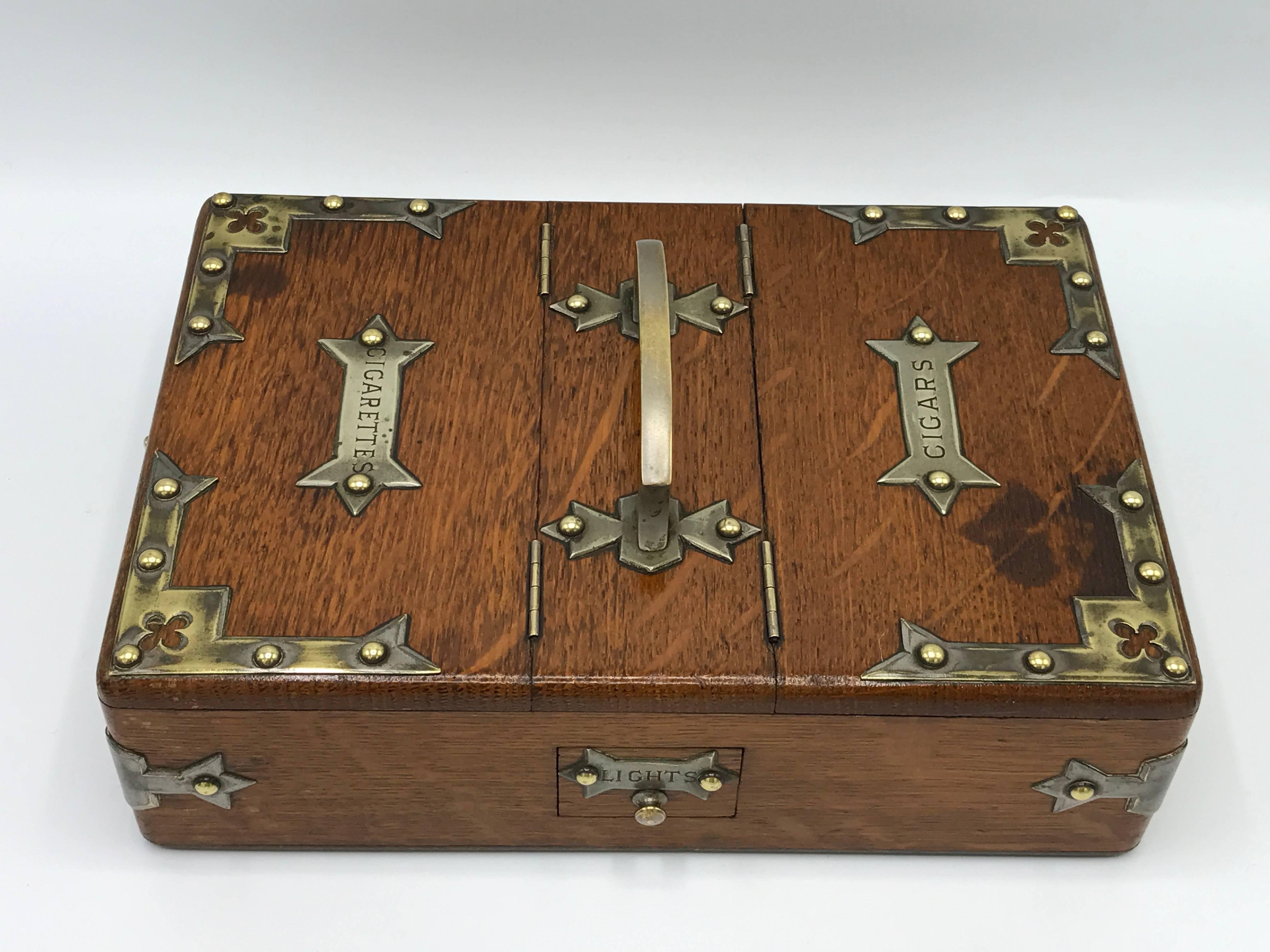 Offered is a stunning, 1940s humidor box. The piece features beautiful, brass Campaign chest style hardware and compartment doors. Two “drawers” for "Lights", one compartment for "Cigars", and one compartment for