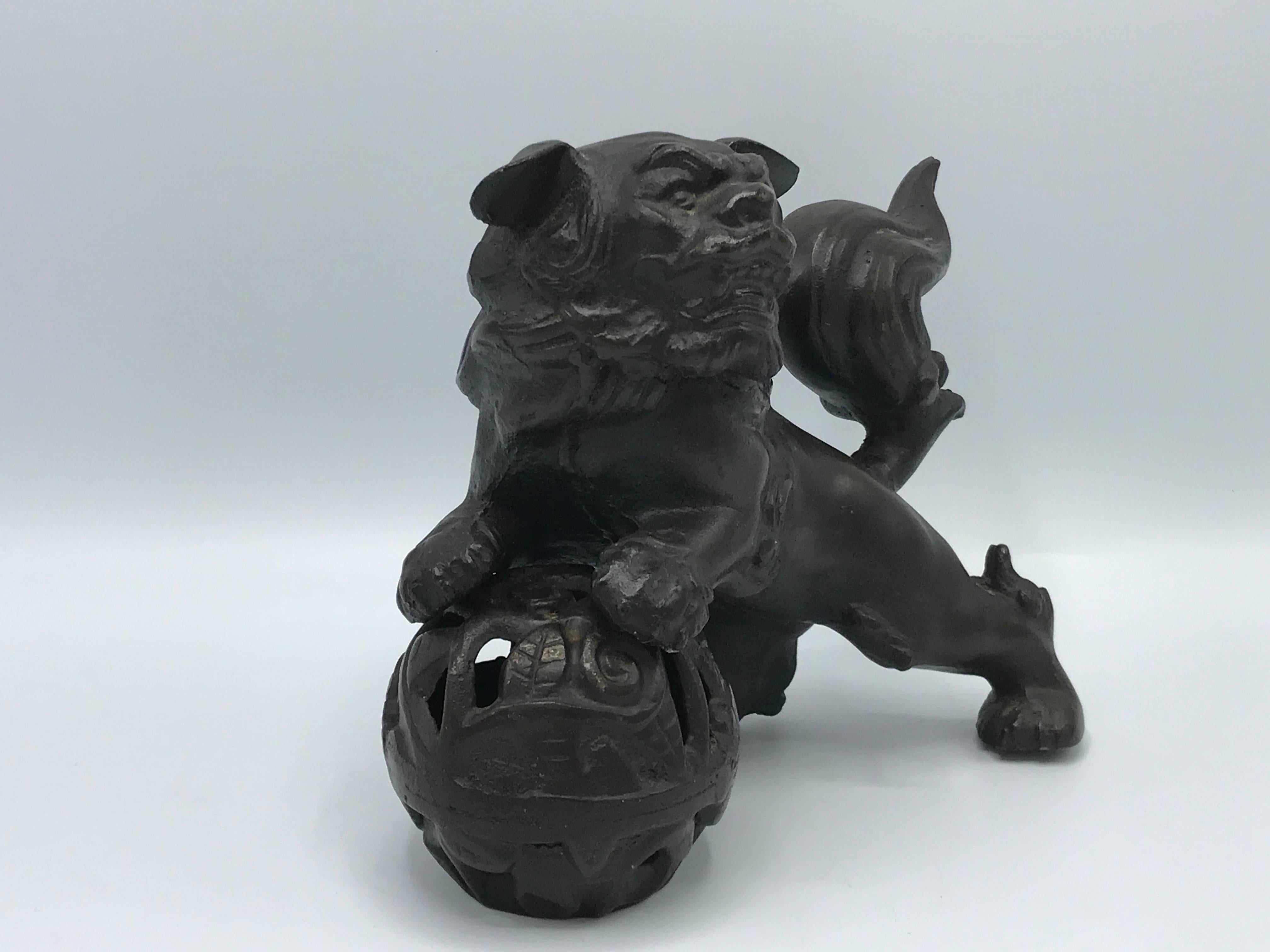 Offered is a stunning, 1930s solid bronze, foo dog statue. The foo dog is rested upon a pierced bronze ball. Pieces are separate (ball and dog).