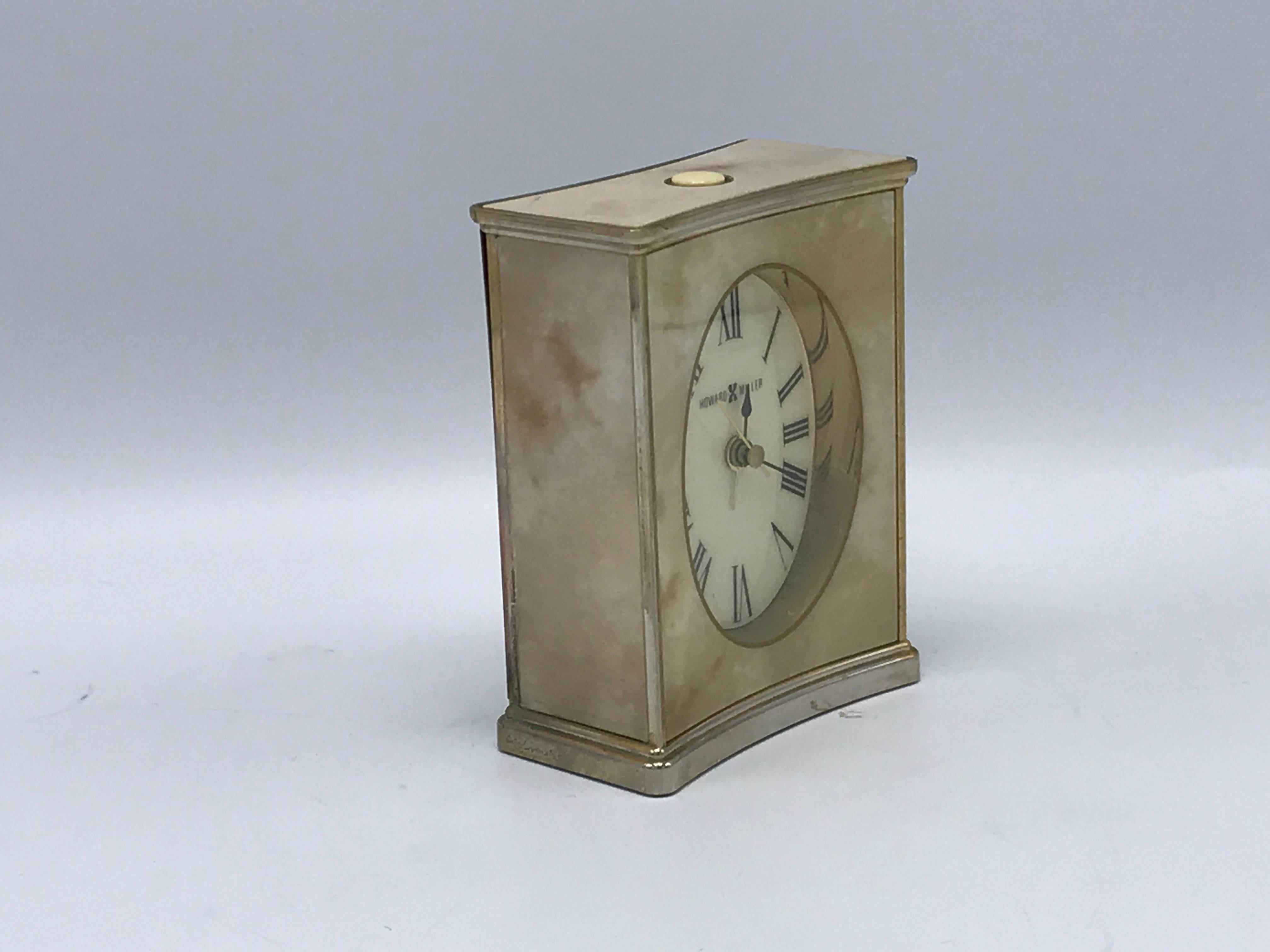 Offered is a beautiful, 1970s Howard Miller faux-marble analog desk clock with a brass border.