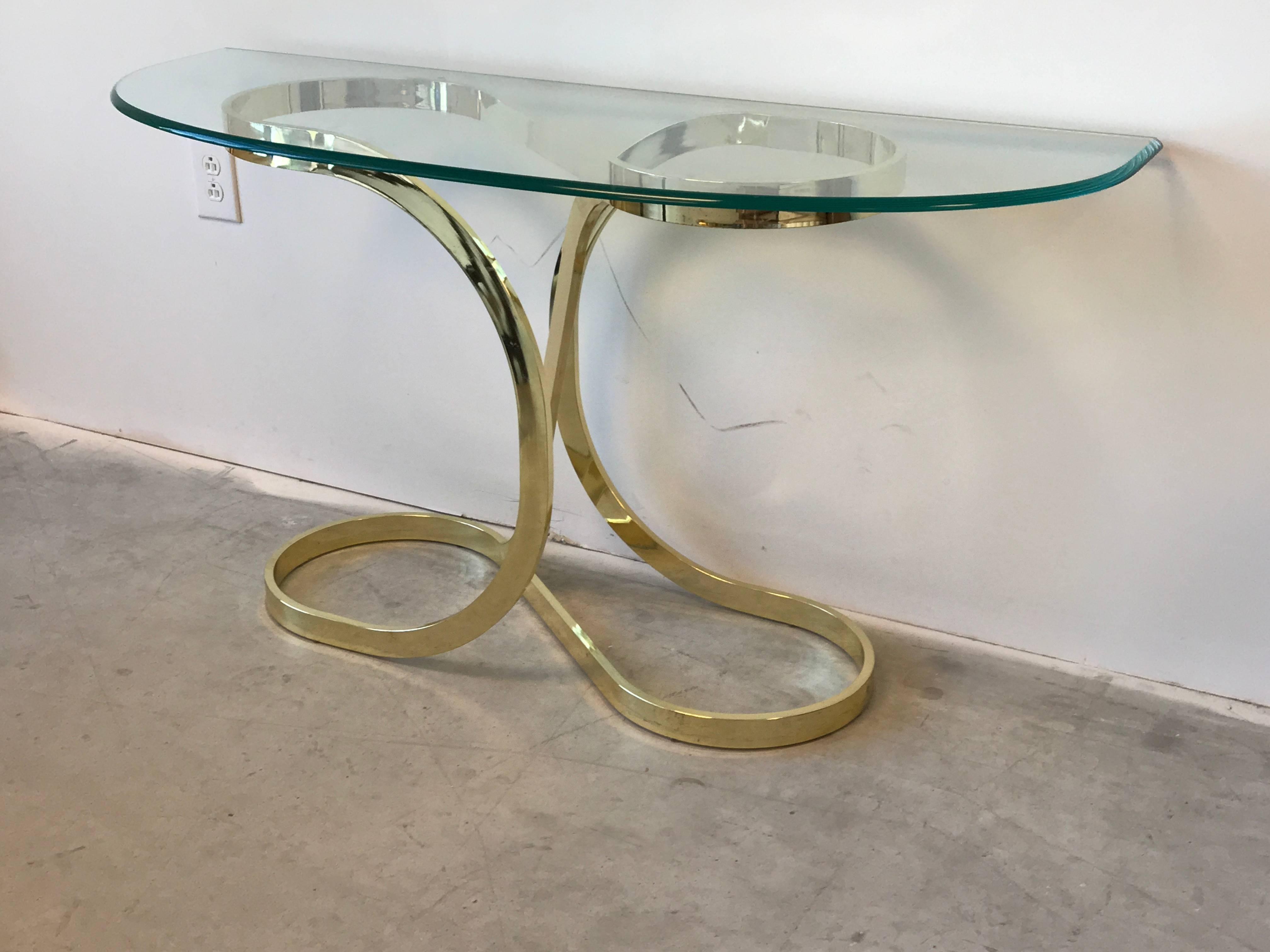 Offered is a gorgeous, 1970s Milo Baughman style brass ribbon console table with glass top. Minor age spots on brass, can be polished. Base can hold a minimum top of 33.5