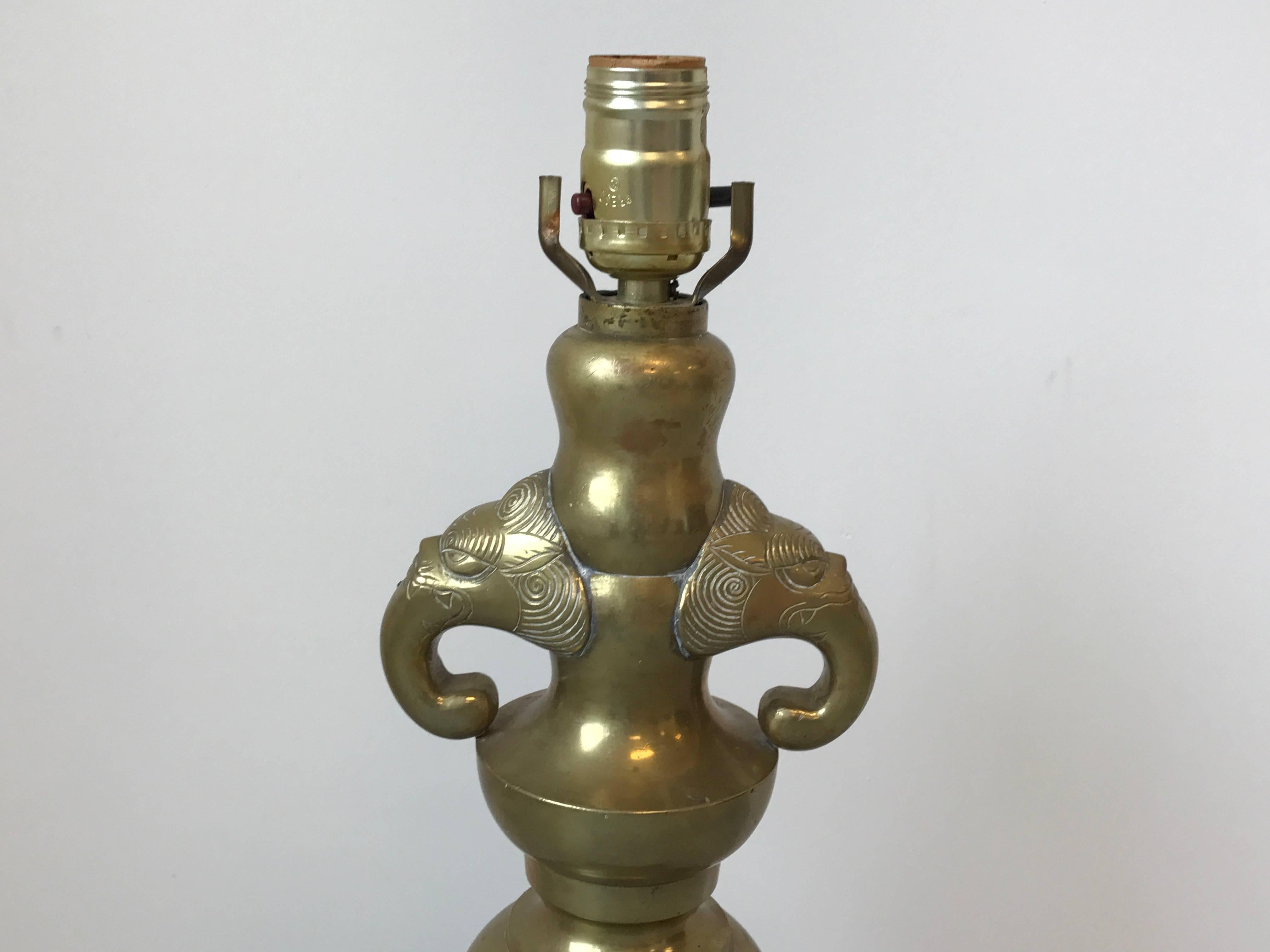 Offered is a beautiful, 1960s brass lamp with elephant head motif on a wooden base.