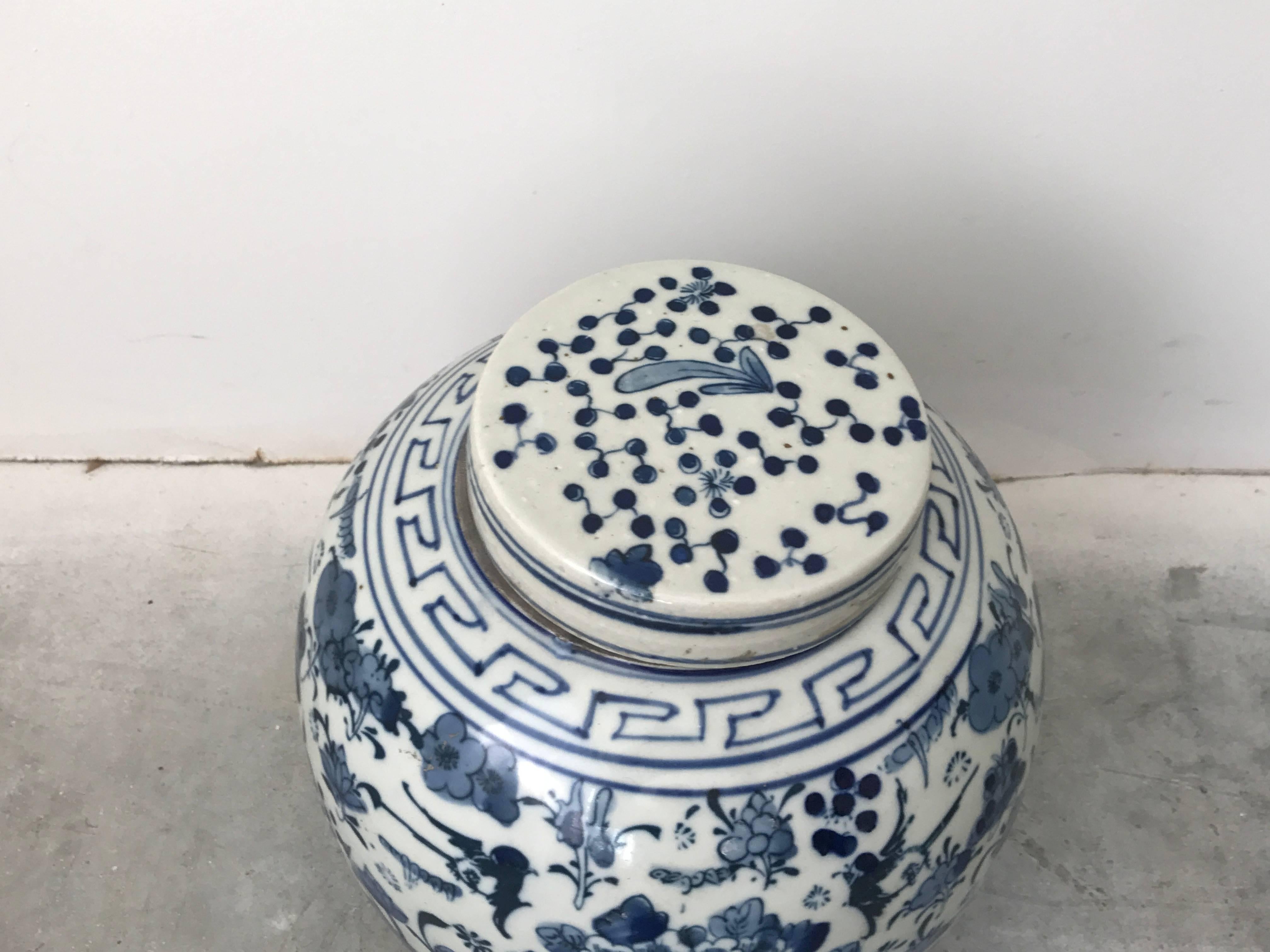 Offered is a gorgeous, late 19th century, Asian blue and white ginger jar with a beautiful cherry blossom tree motif on each side. Greek key detailing along the top of the jar, near lid.