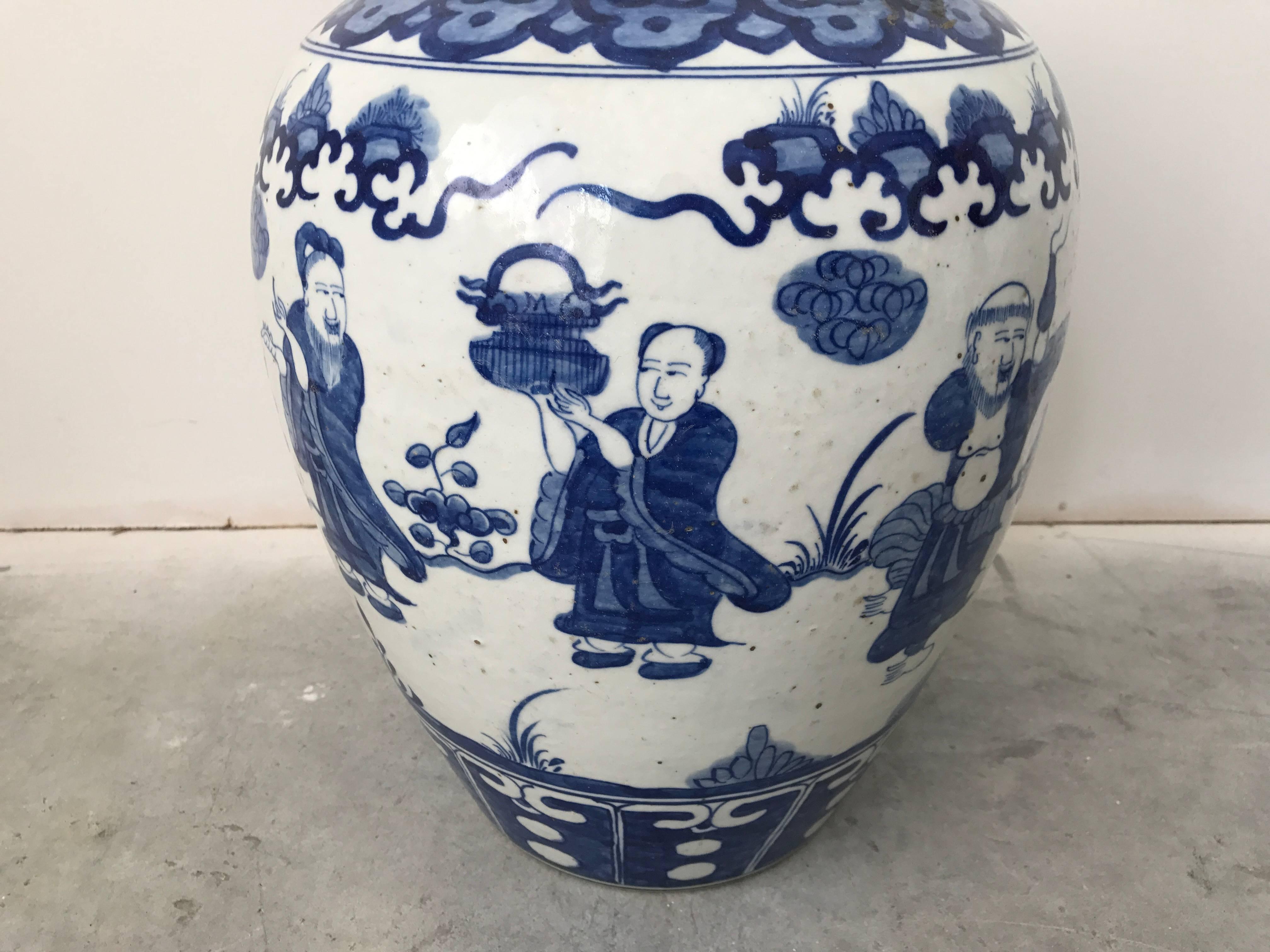 Offered is a stunning, large blue and white ginger jar urn with ornate scenery on all sides. Brass hook-handle on lid.