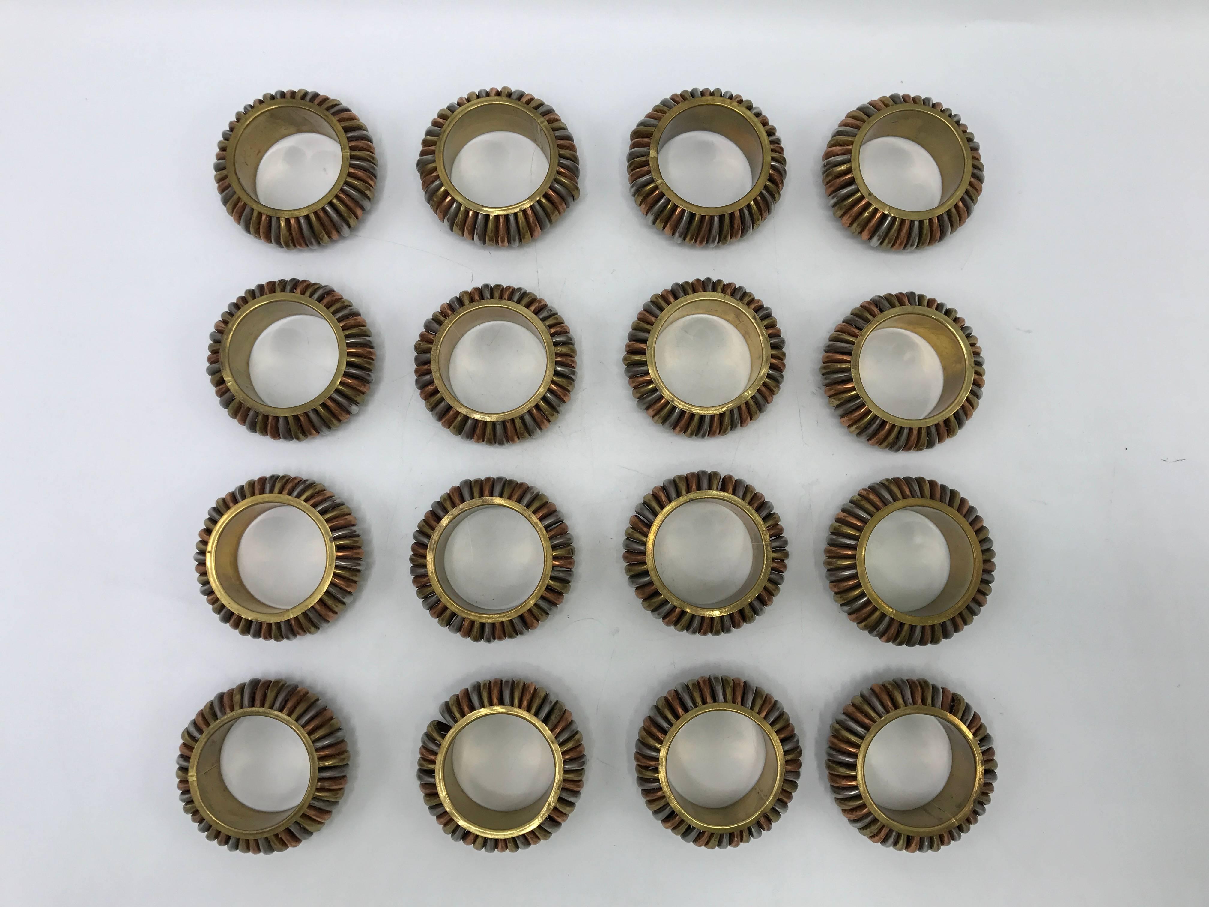 Offered is a gorgeous, set of 16, 1970s brass, copper and steel/silver napkin rings. Modern, sophisticated and handsome look for any table setting.
