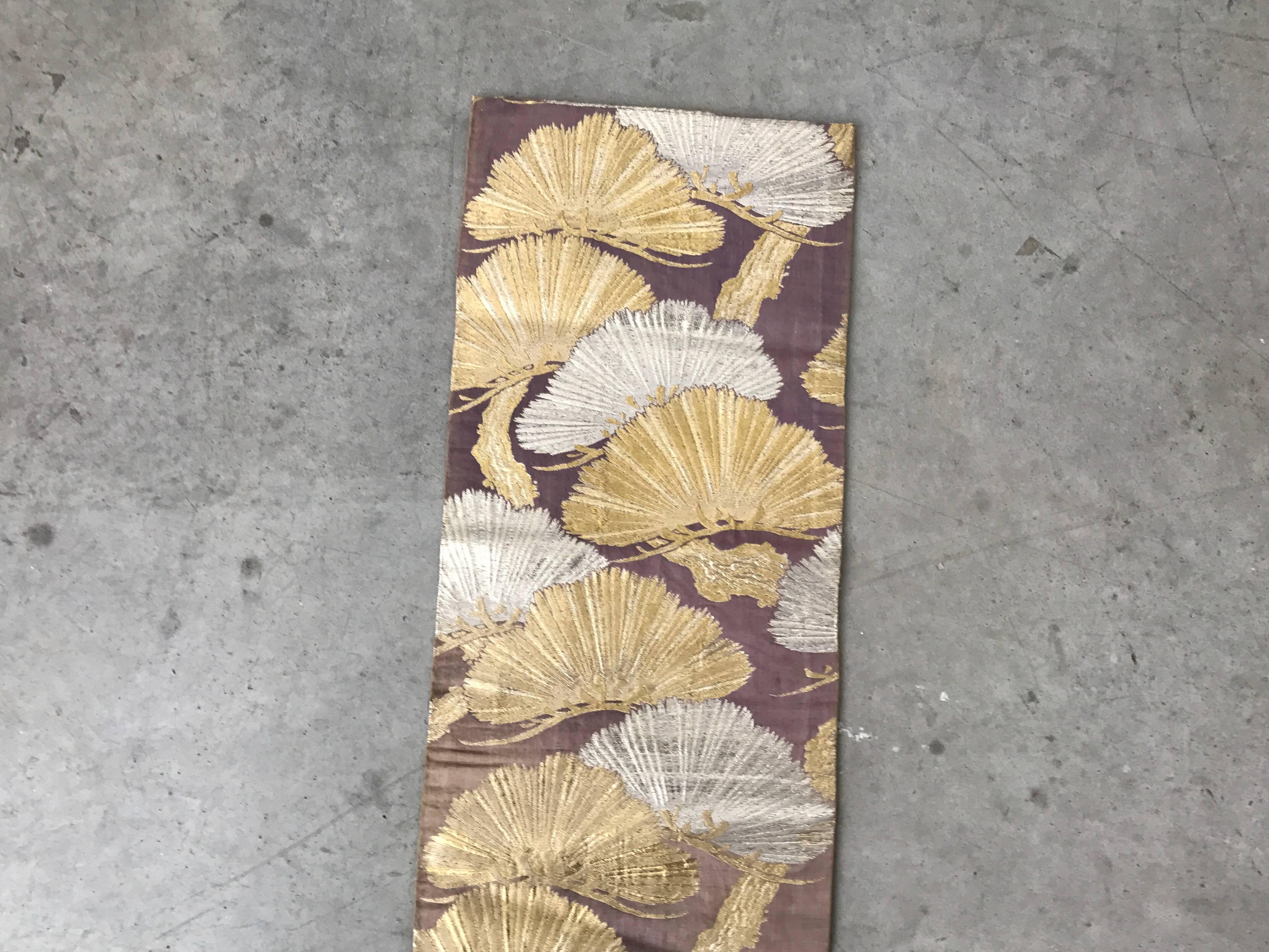 Offered is an exquisite, 1960s Japanese Obi wrap that's been converted into a gorgeous table runner. Purple fabric, with silver and gold embroidered ginkgo leaves, repeating on each side. Minor color fading, expected with age. Dry clean only.