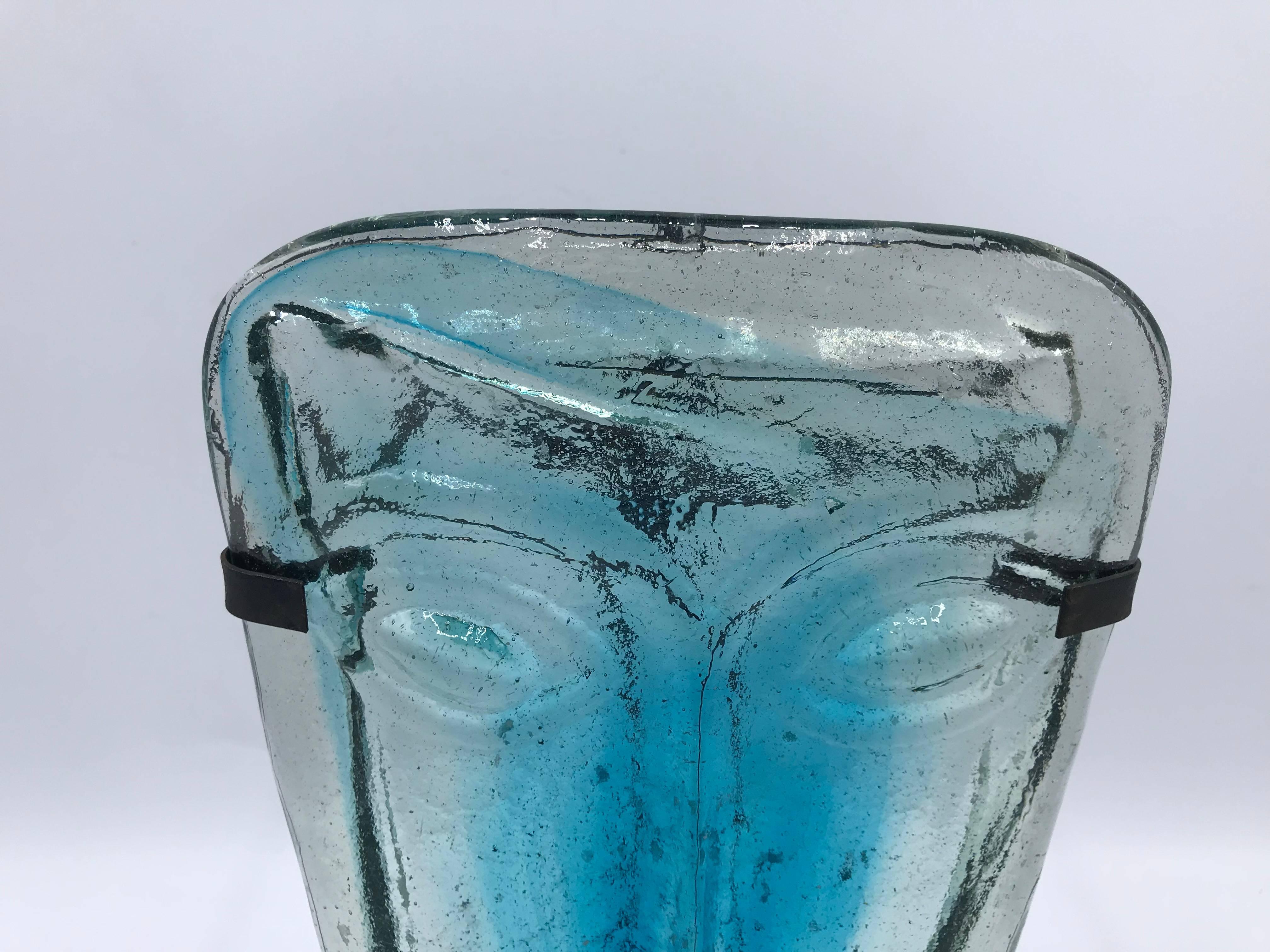 Offered is an exquisite, 1960s Erik Hoglund for Kosta Boda blue and clear art-glass face mask. The piece is attached to a handmade steel frame, that can hang on the wall, or stand on a table with candle. The piece is extremely rare and one of a kind!