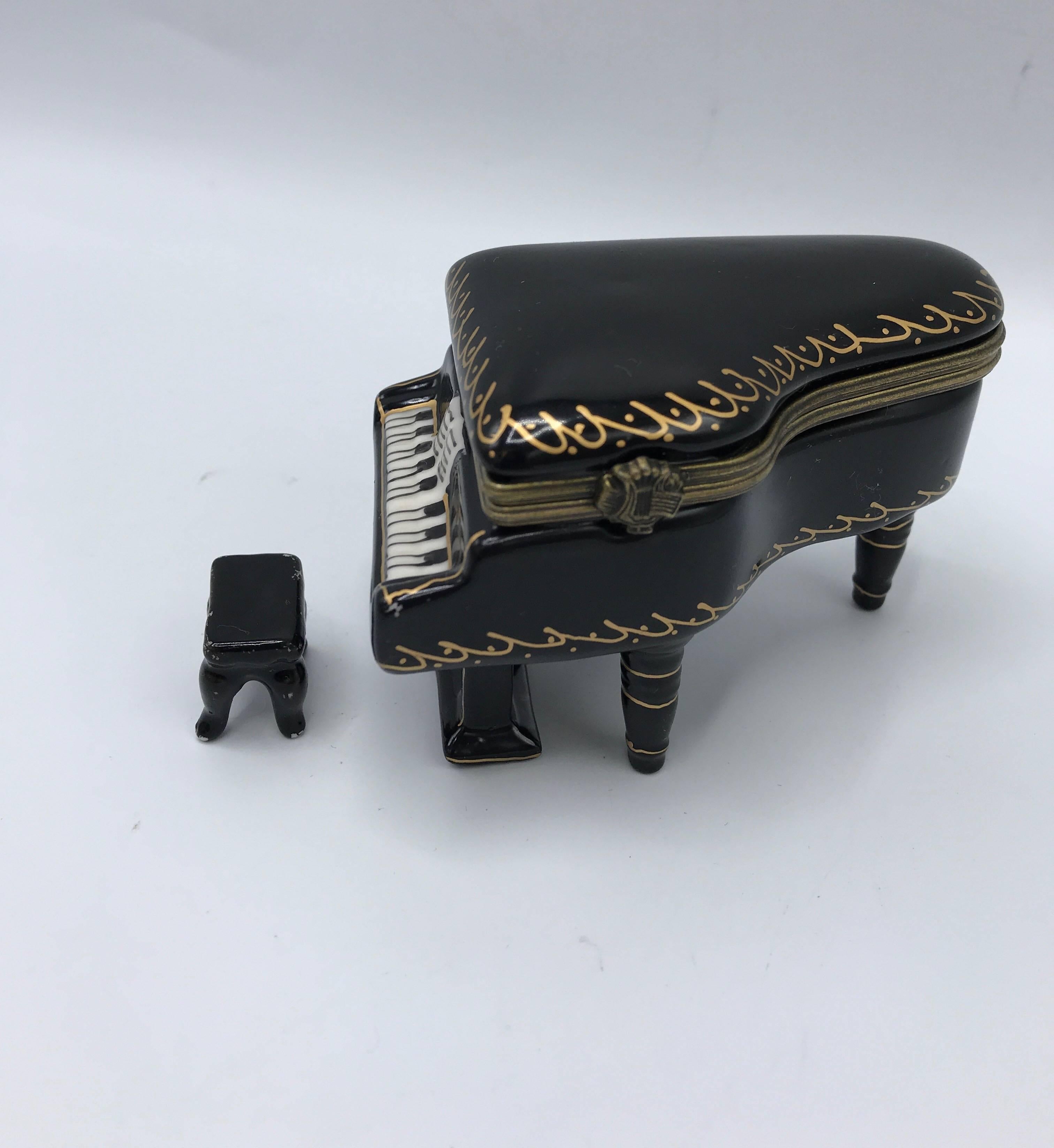Offered is an exquisite, 1960s French Limoges-style black and gold porcelain trinket box, in the shape of a grand piano. Includes a matching, miniature to-scale piano bench. Clasp and hinge are in excellent condition, still closing tightly.