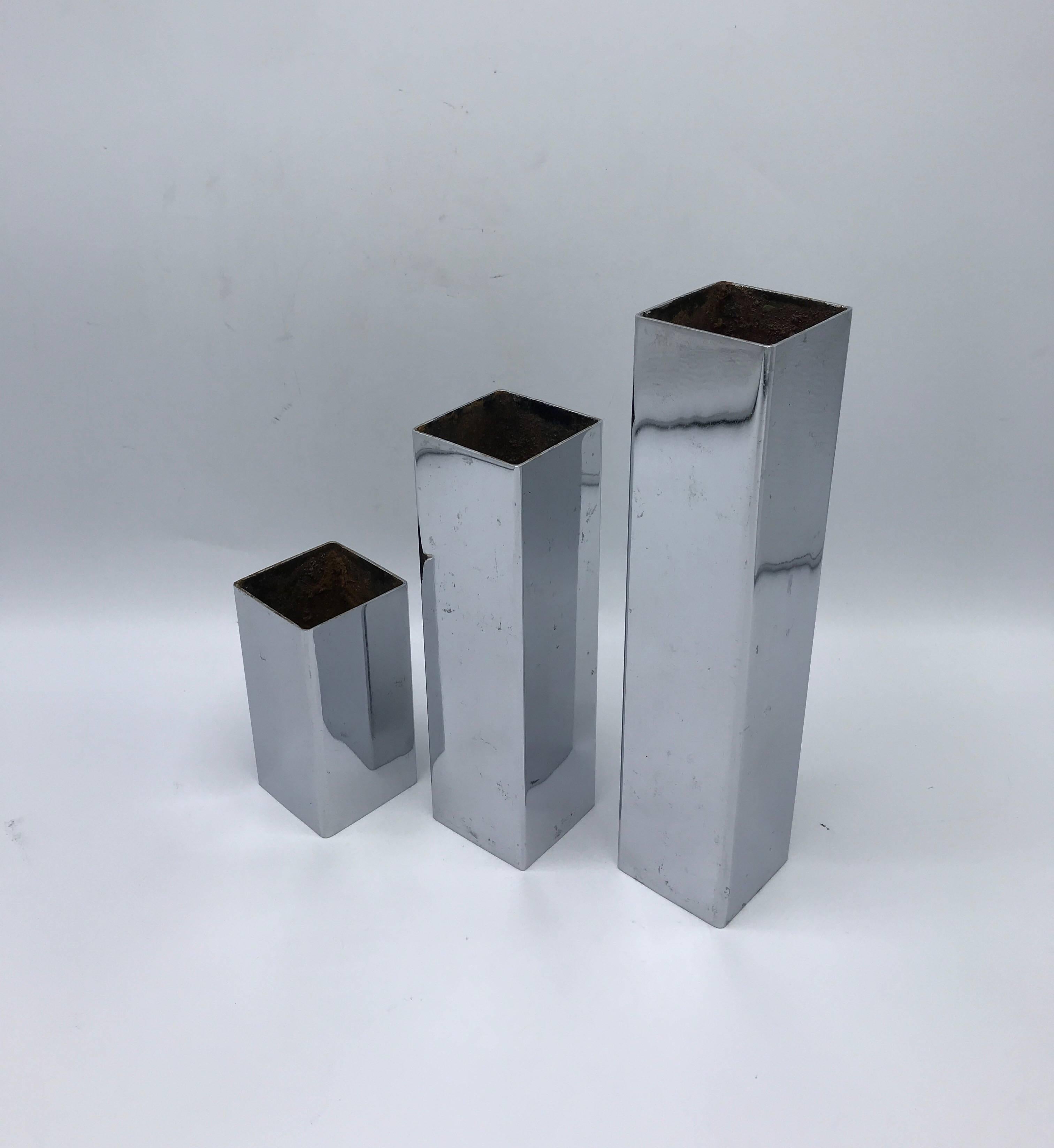 Offered is a modern and sophisticated, set of three, 1970s Ikebana chrome column vases/candleholders. 

Measure: Small 2” x 2” x 4” 
Medium 2” x 2” x 7”
Large 2” x 2” x 9”.
 
