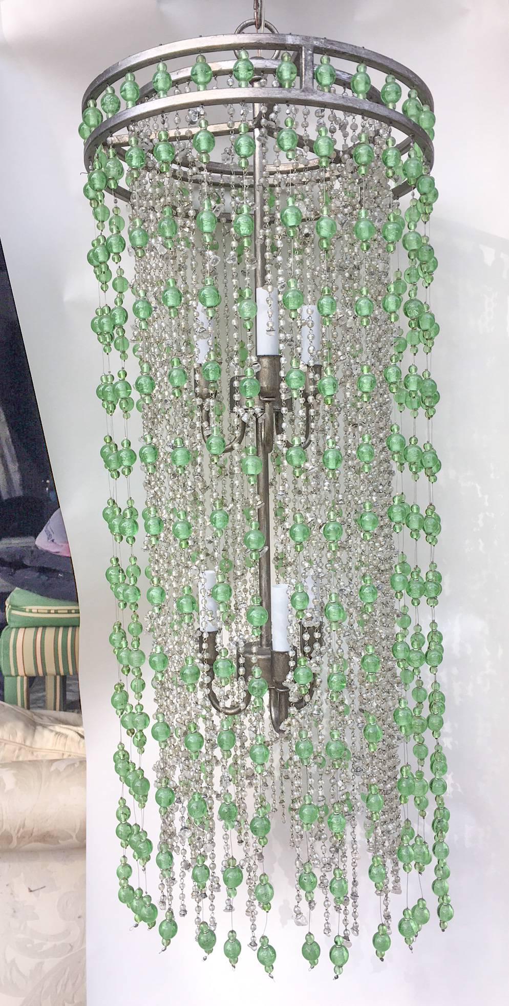 Beyond fabulous statement chandelier by the renowned Arteriors Home, featuring strings of individually hand-tied green and clear glass beads in various sizes and lengths on silver wire. The frame is silver leaf painted metal and includes two