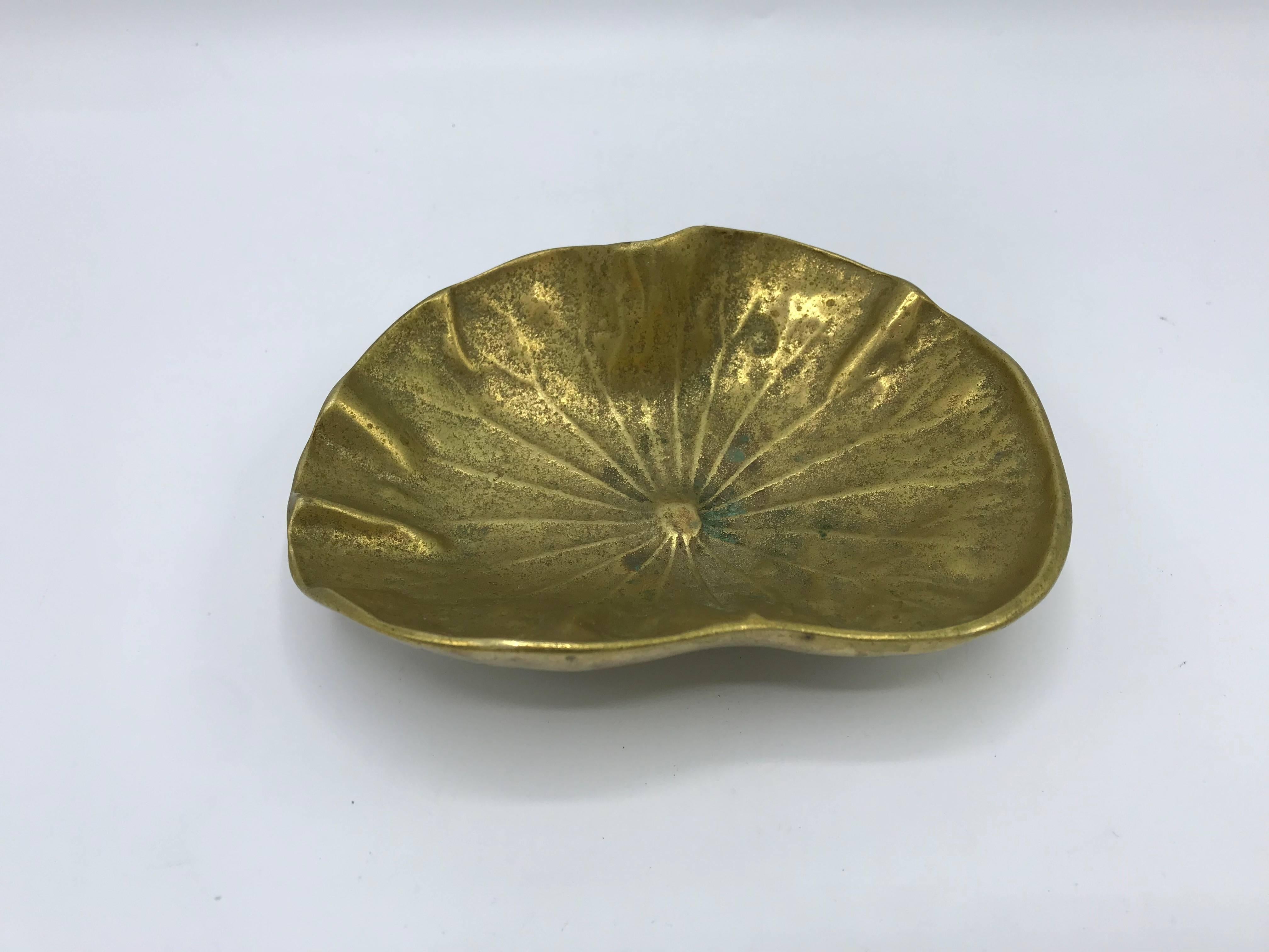 Offered is a stunning, 1940s Virginia Metalcrafters solid-brass lotus leaf dish. Marked on backside: '1948' with Virginia Metalcrafters signature 'VMC' stamp. Heavy.

“Since 1890, the Virginia Metalcrafters hallmark has become synonymous with fine