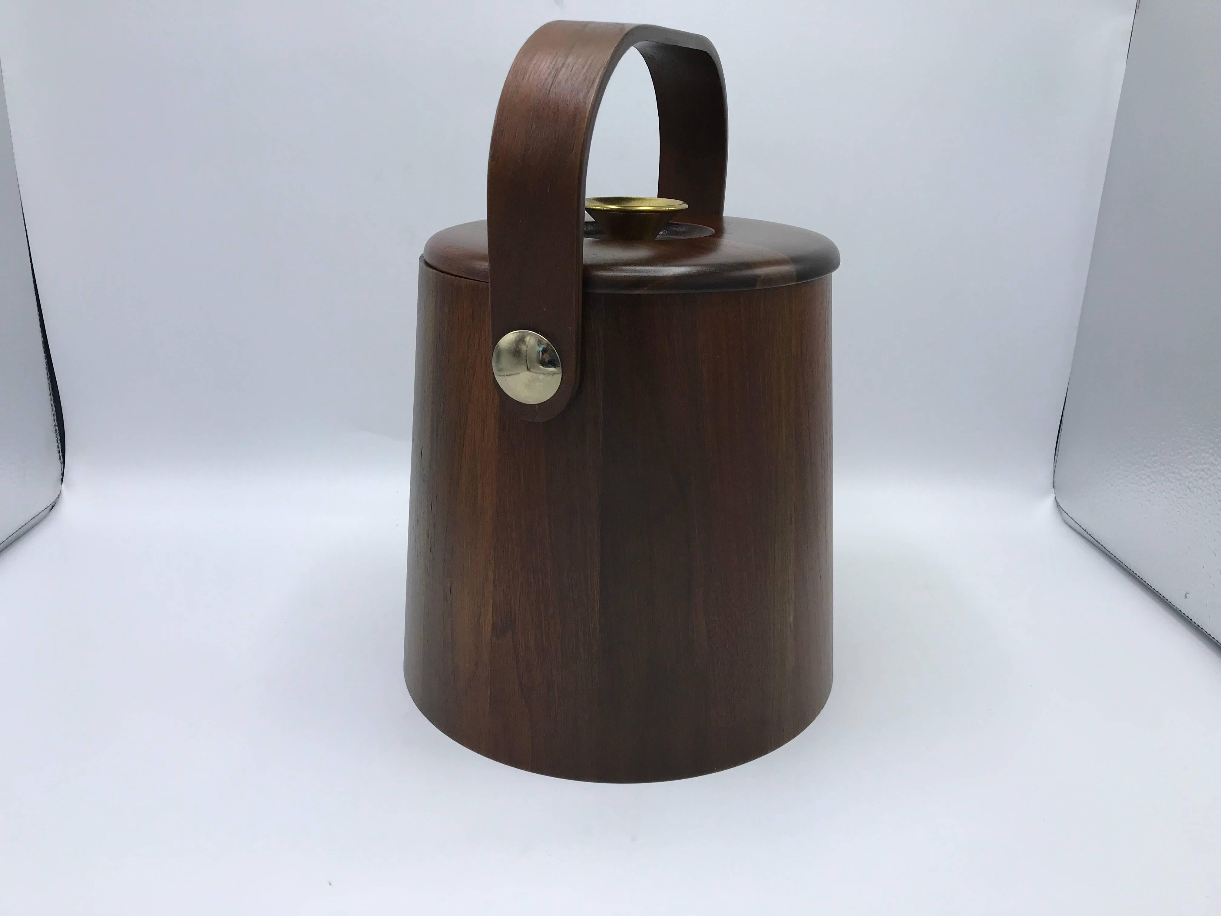 Listed is a modern and sophisticated, 1960s solid-walnut ice bucket with brass hardware. Large enough to be a wine or champagne chiller. The piece includes the original plastic liner. Heavy.