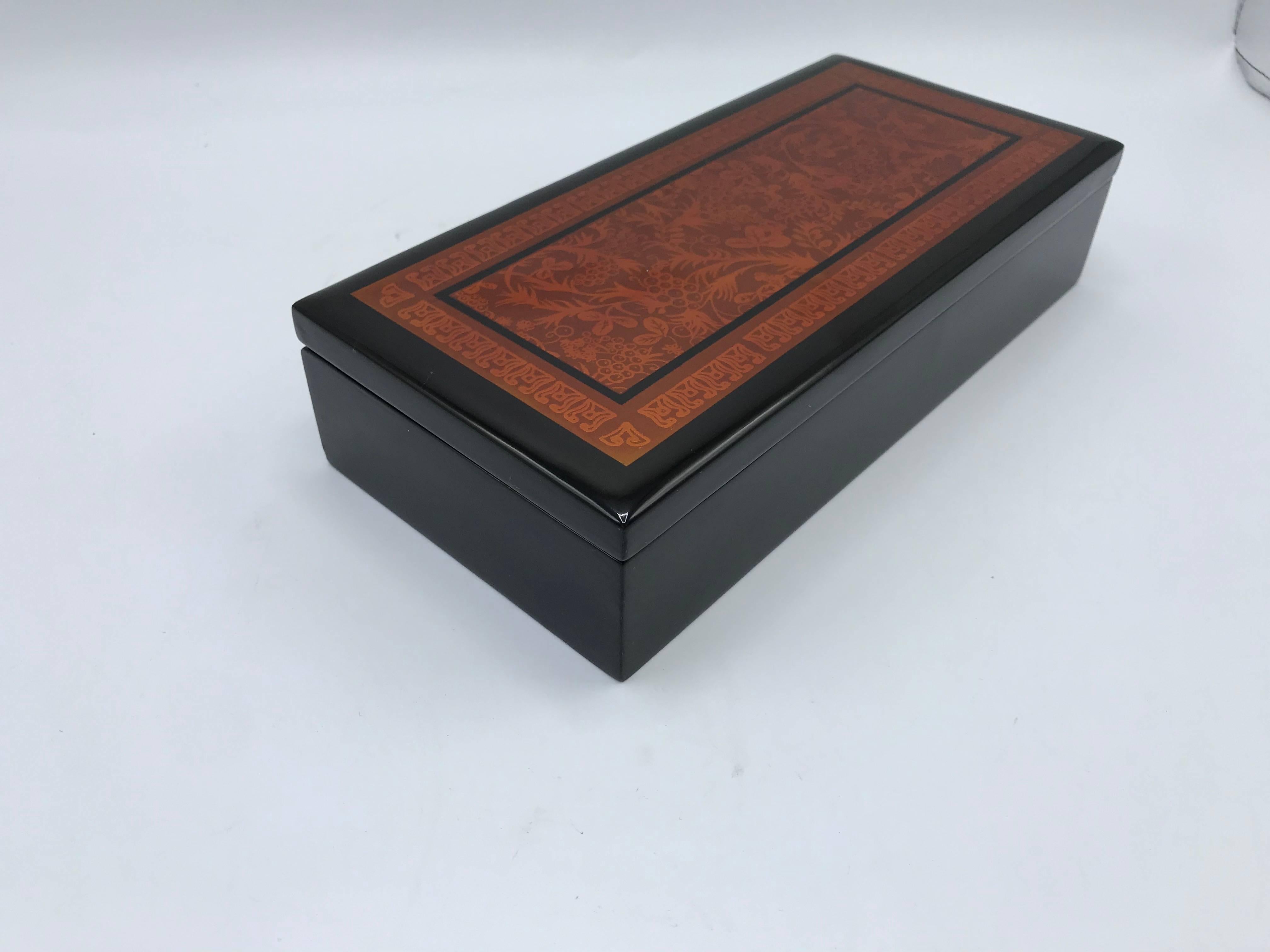 Offered is a fabulous, 1970s chinoiserie red and black lacquered box with an ornate motif on the lid. Hinged and lidded.