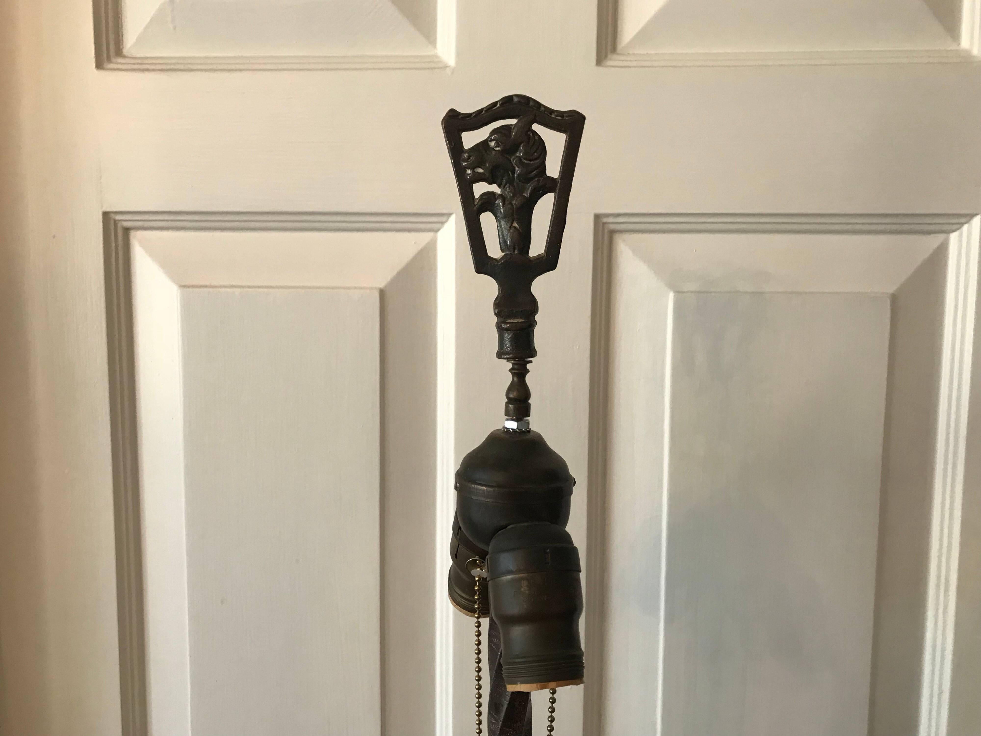 Listed is a substantial and stunning, 1920s Art Deco vibrant green jadeite and bronze floor lamp. Vibrant chartreuse and emerald greens. The piece includes its original bronze finial with a sculptural goat motif. Double socket, original hardware.